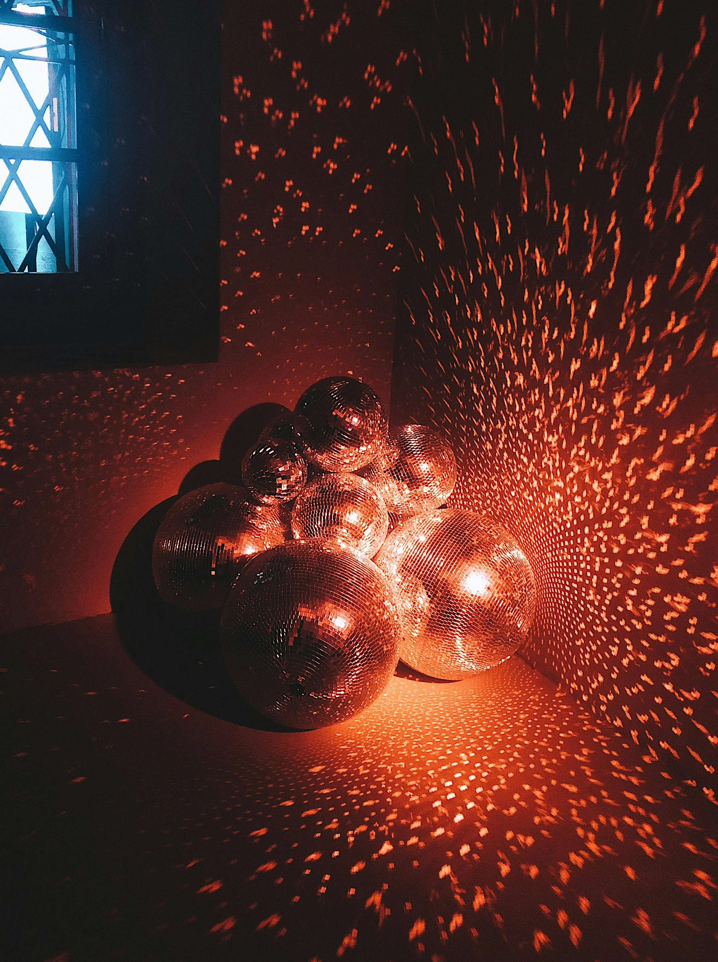 Ballons disco en reflection sur le mur et le sol, avec un éclairage rouge et une couronne de lumière