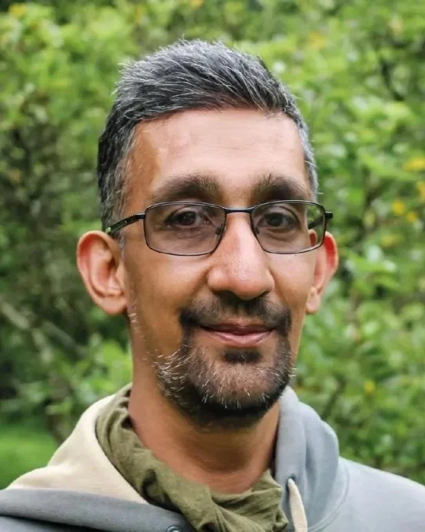 headshot of a man with glasses and grey hair looking into the camera