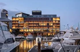 Waterfront hotel building with boats docked in a marina during evening.