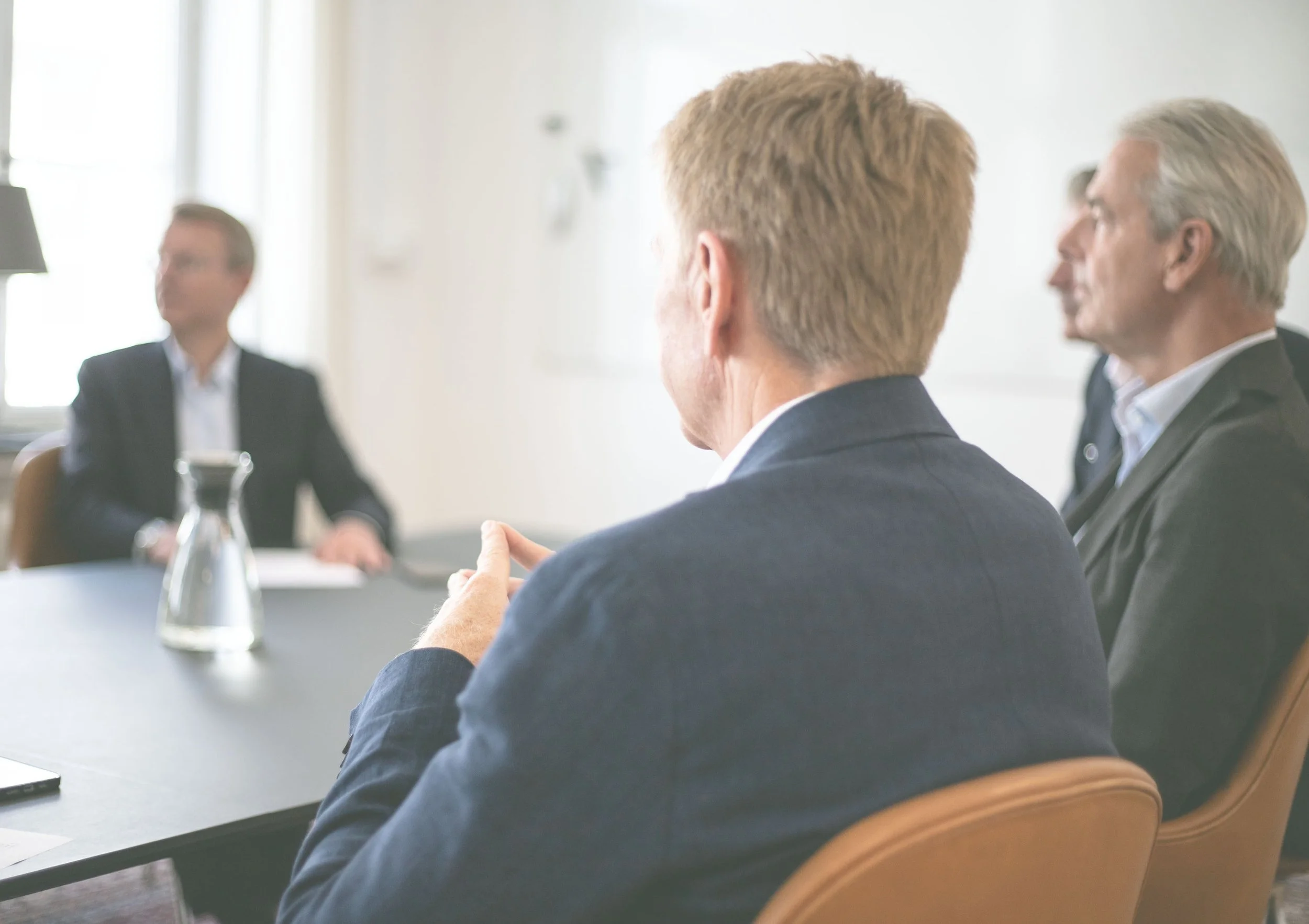 Close-up view of a modern multi-story building with angled glass windows and white panels, creating a geometric pattern.