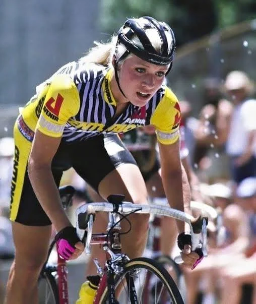 •  	• Ten-time National Champion and Olympic cyclist Marianne Berglund intensely riding a racing bike during a competitive race.