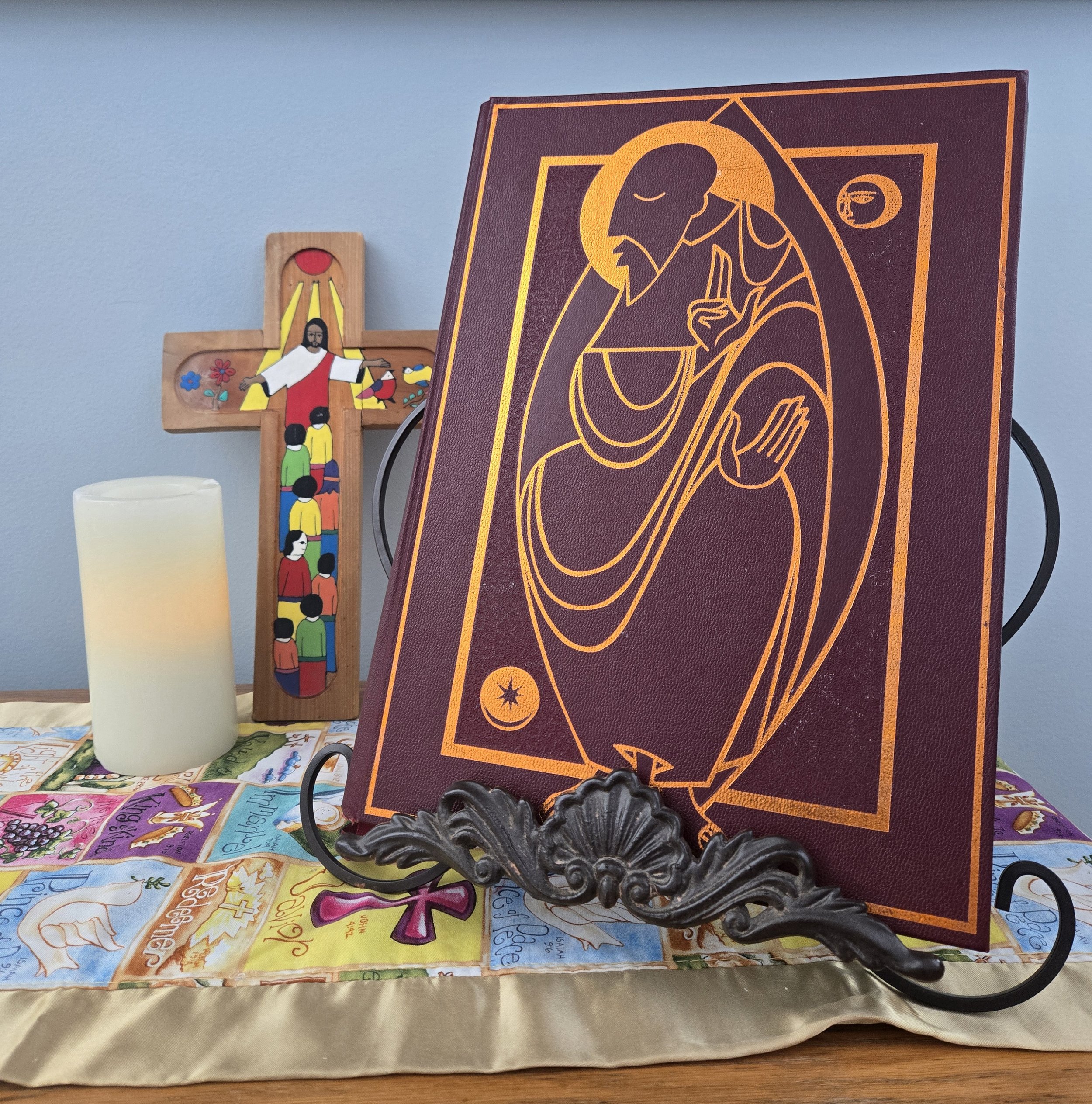 Image of book, candle, and cross showing Jesus with children.