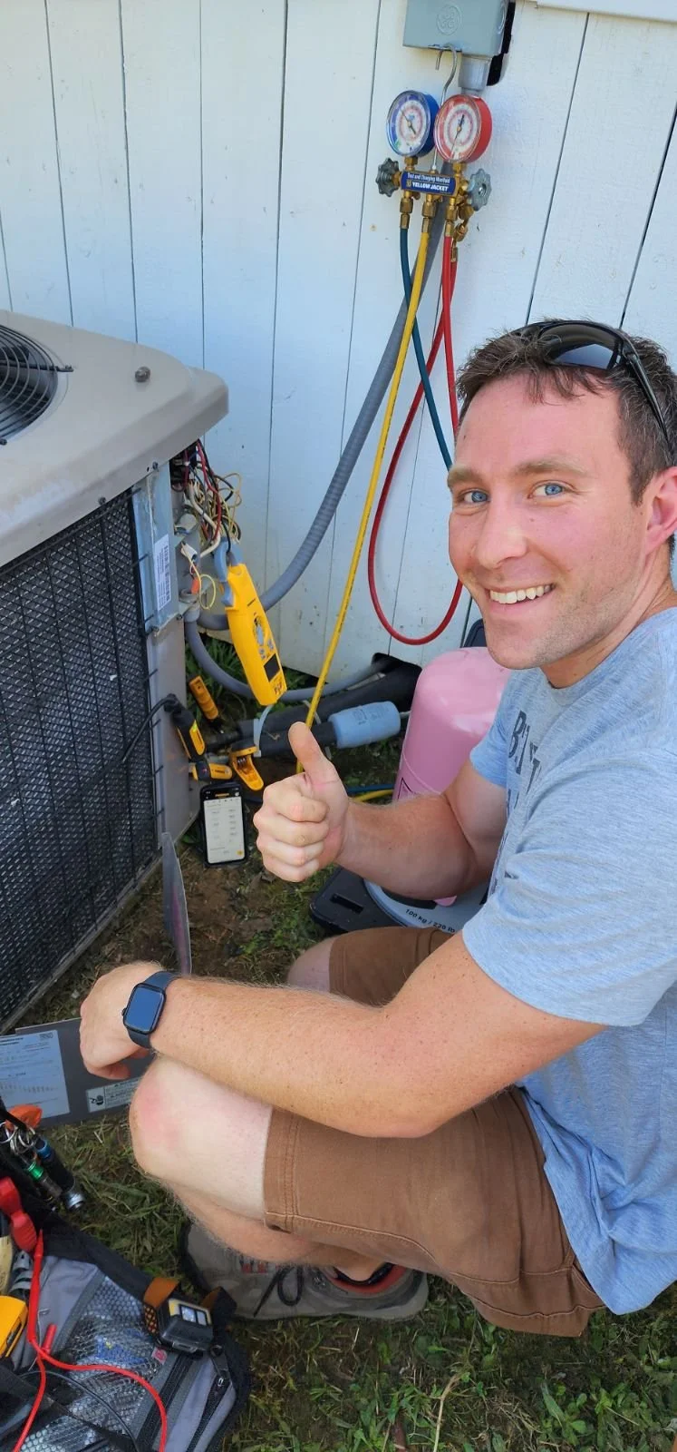 Beers HVAC contractor Niles Beers is smiling and giving a thumbs up next to a condenser while doing an AC repair in Bartlett, TN. In the background, he is using the most up-to-date diagnostic and repair equipment.
