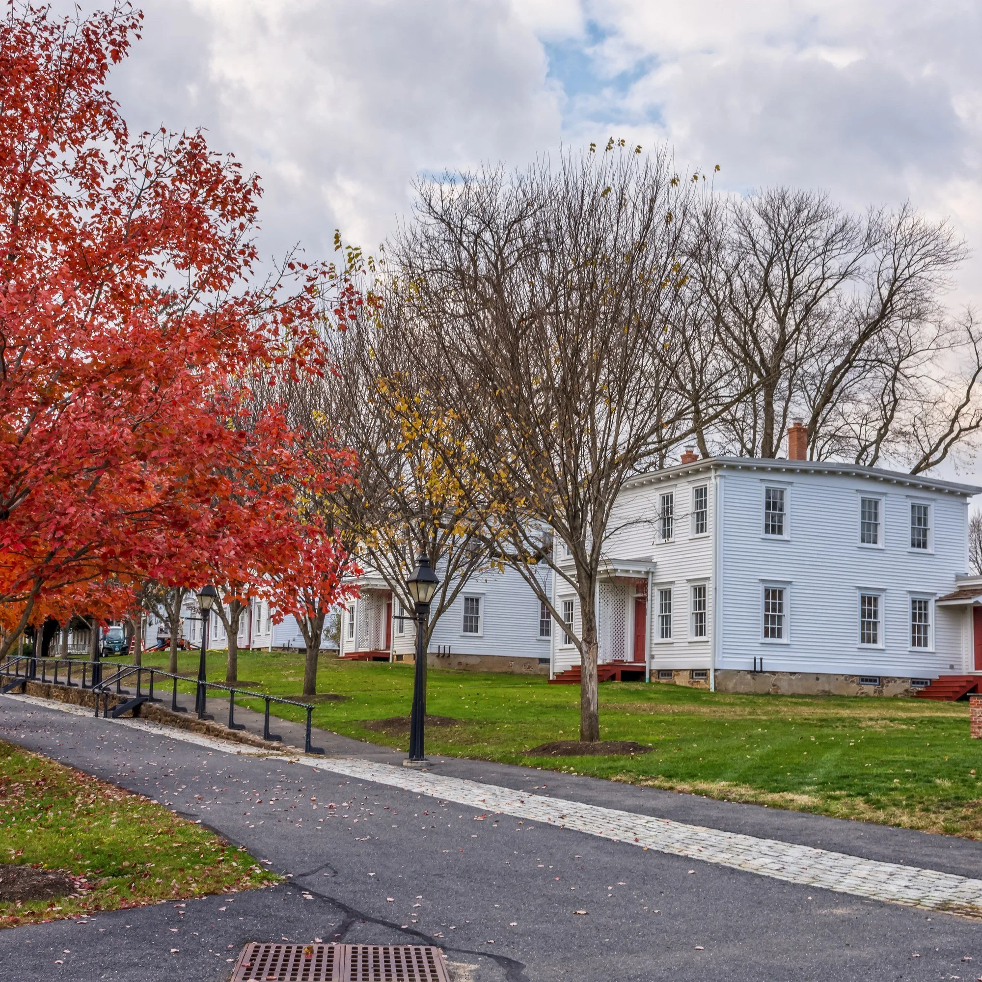 Historic homes in Smithville, New Jersey, with autumn trees along a path.