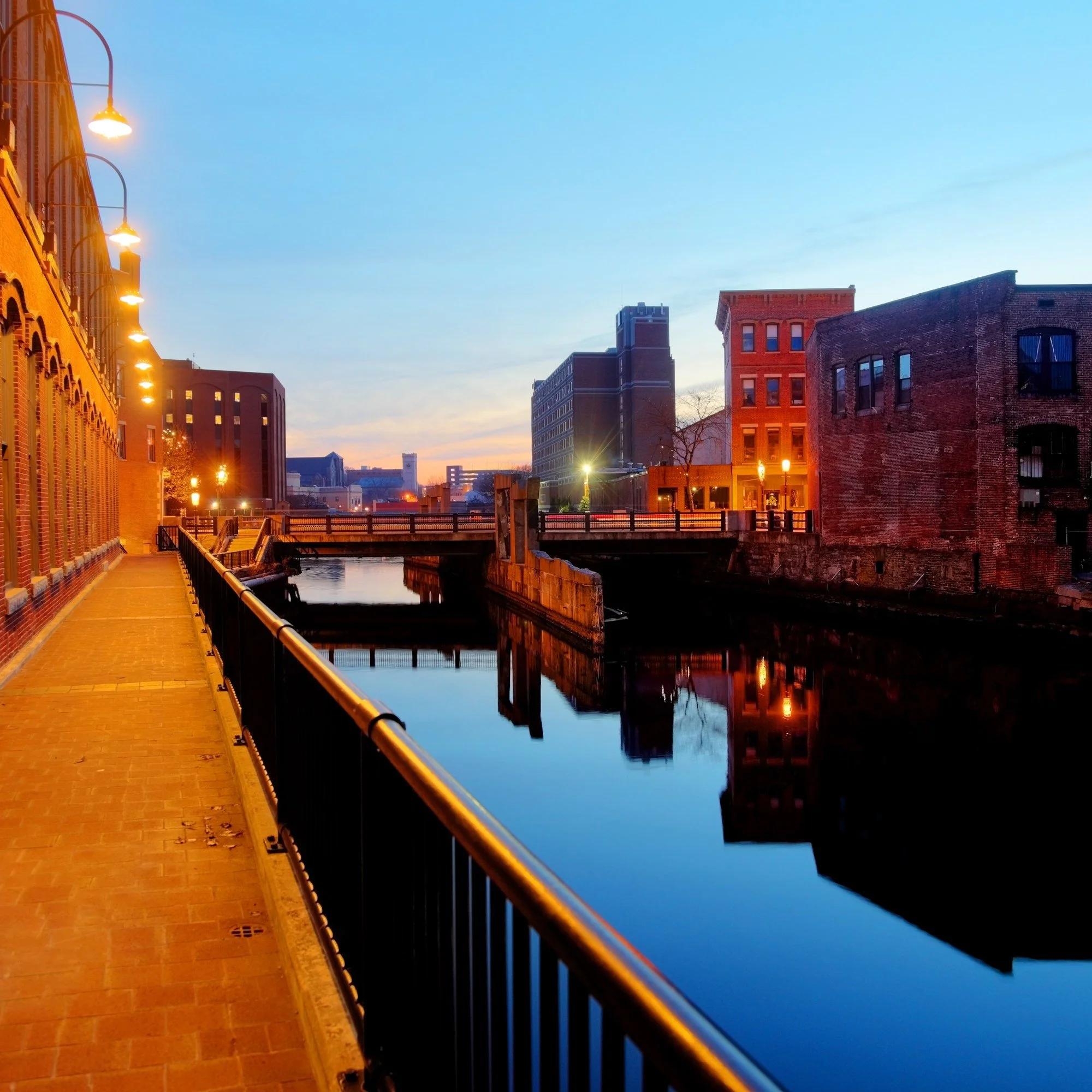 A canal walk past the mill buildings in Lowell, Massachusetts, at dusk.