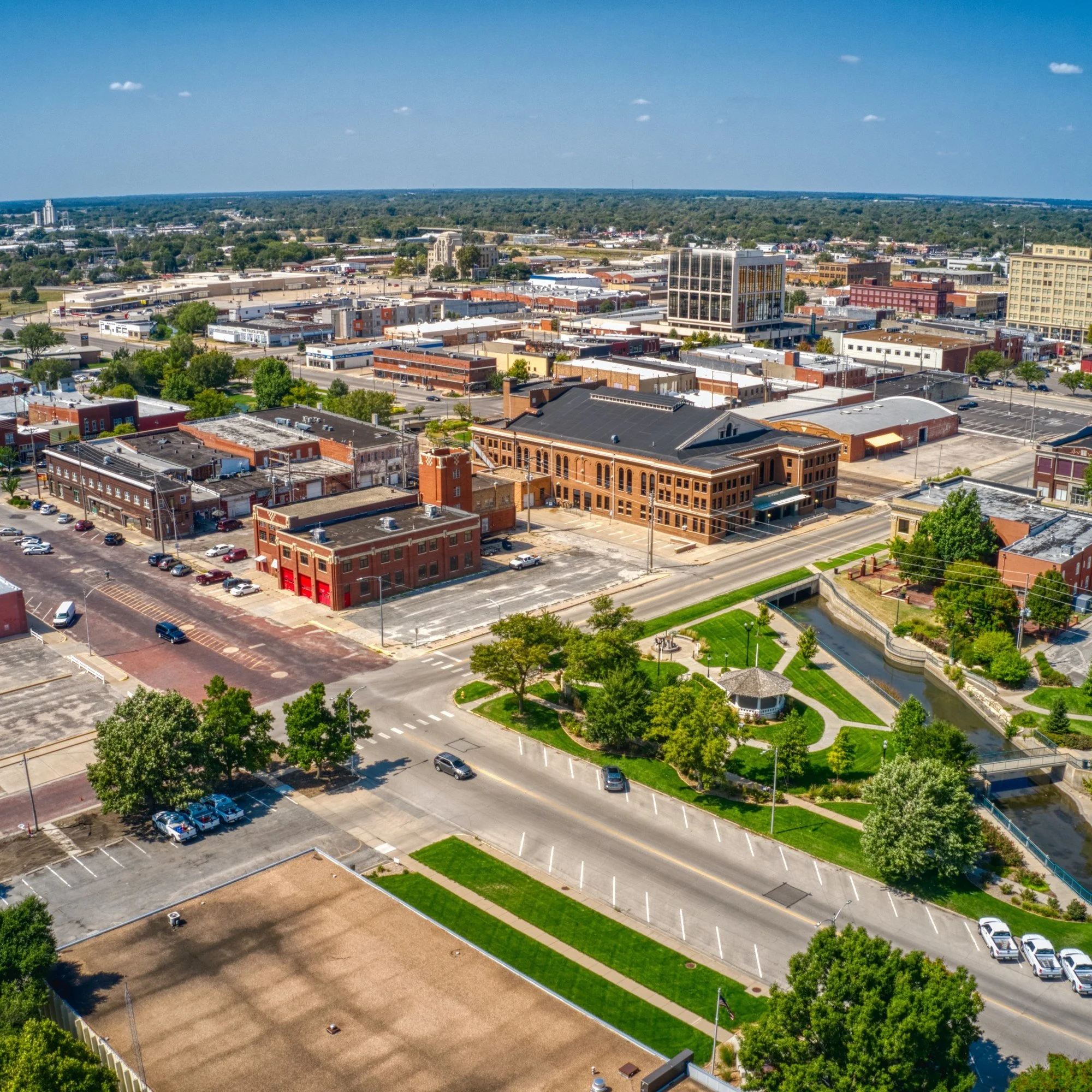 Aerial view of downtown Hutchinson, Kansas, on a summer day, with brick buildings, a park, and a water tower.