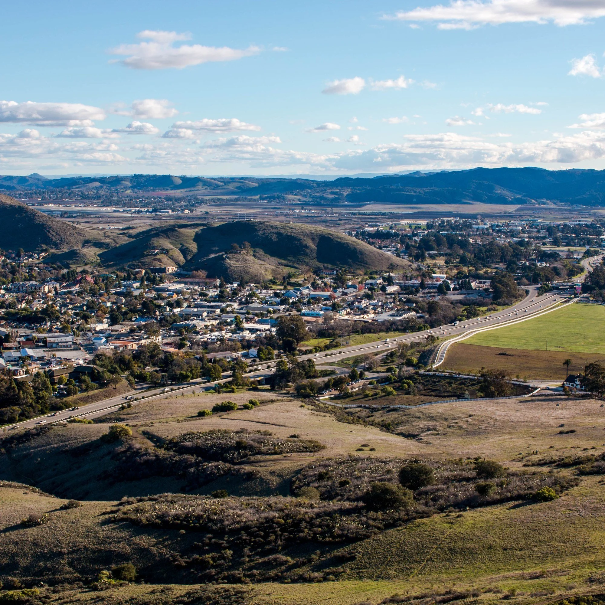 San Luis Obispo, California, seen from the hills, with rounded peaks beyond the town.