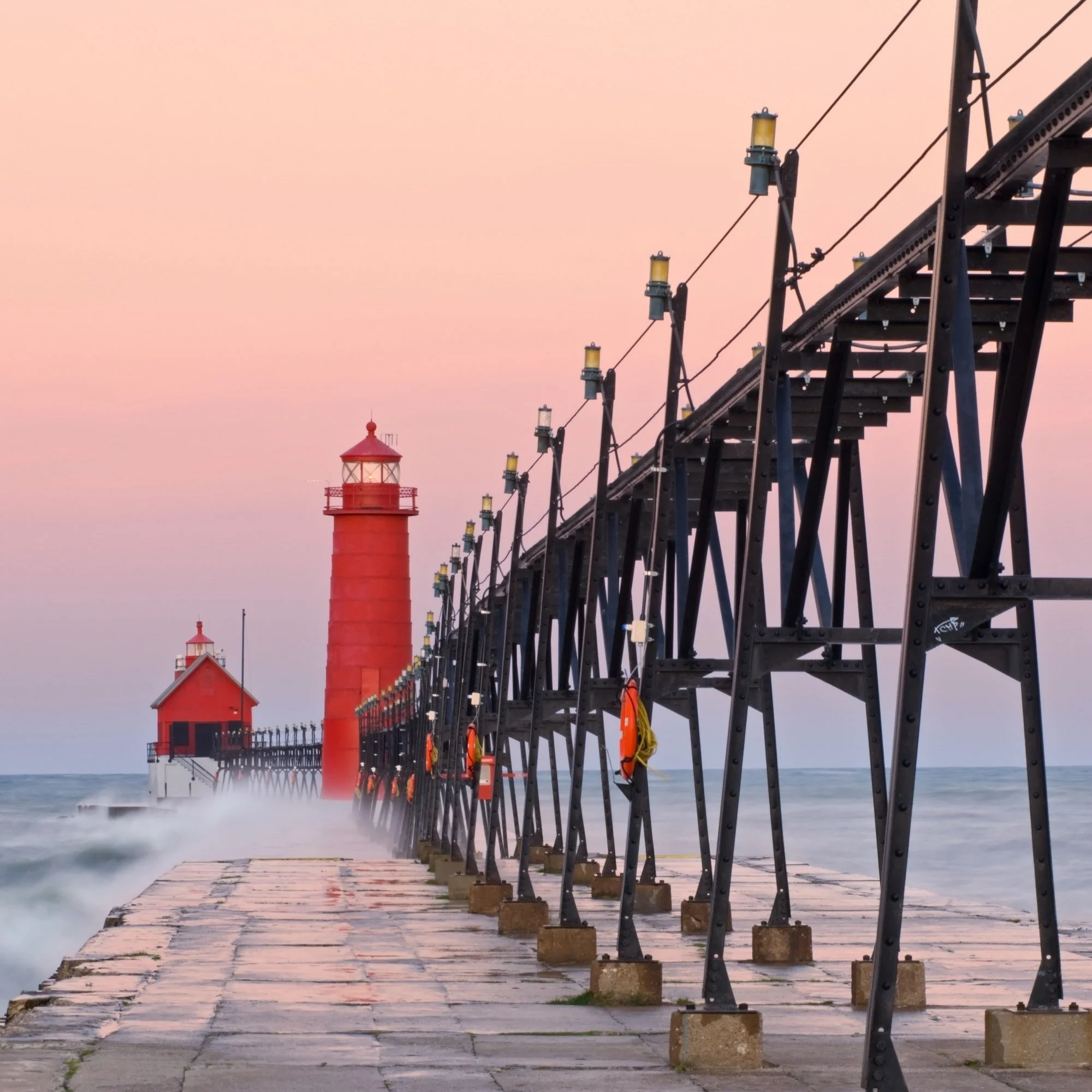 The red lighthouse and catwalk on the Grand Haven, Michigan, pier at dawn.