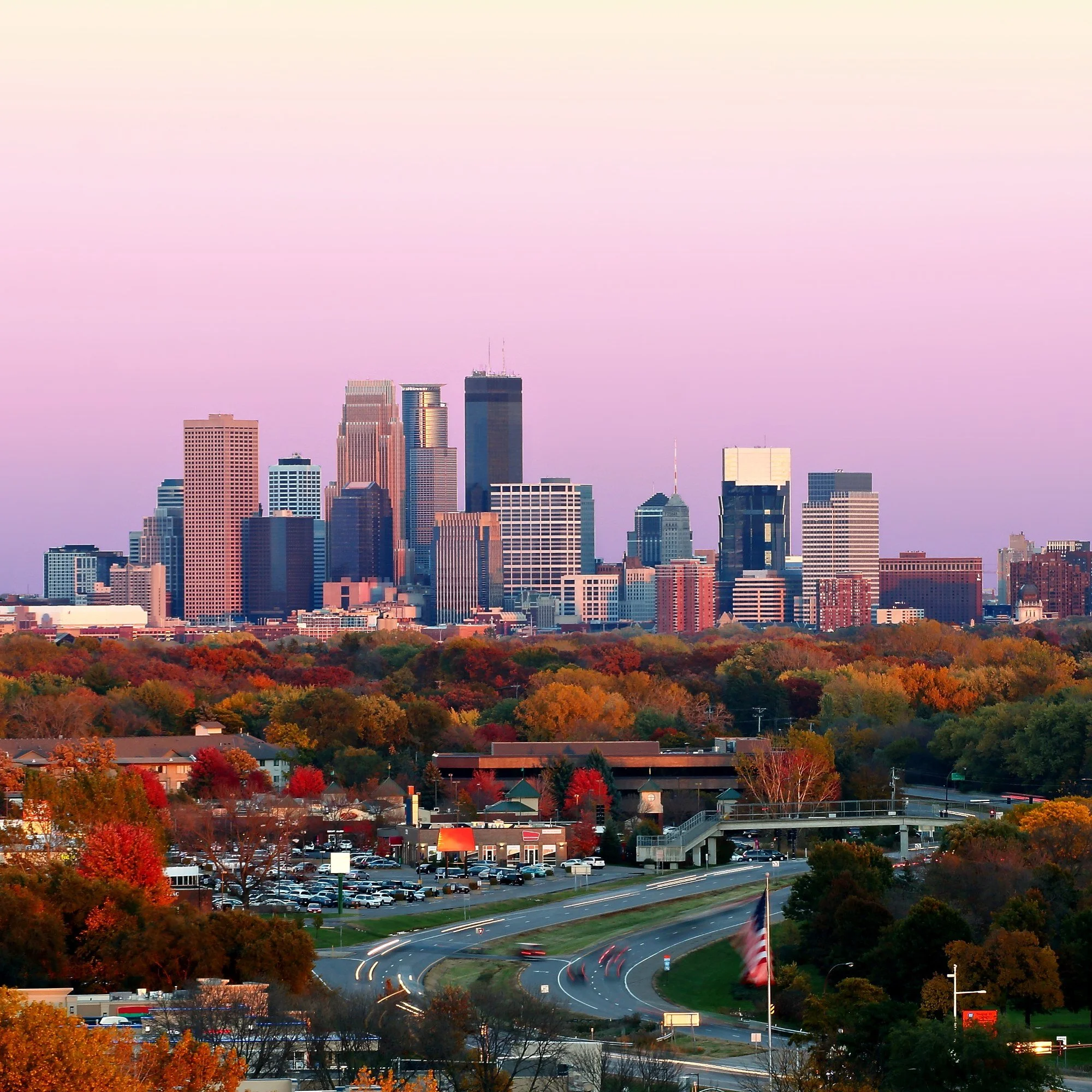 The Minneapolis, Minnesota, skyline above fall color at sunset.