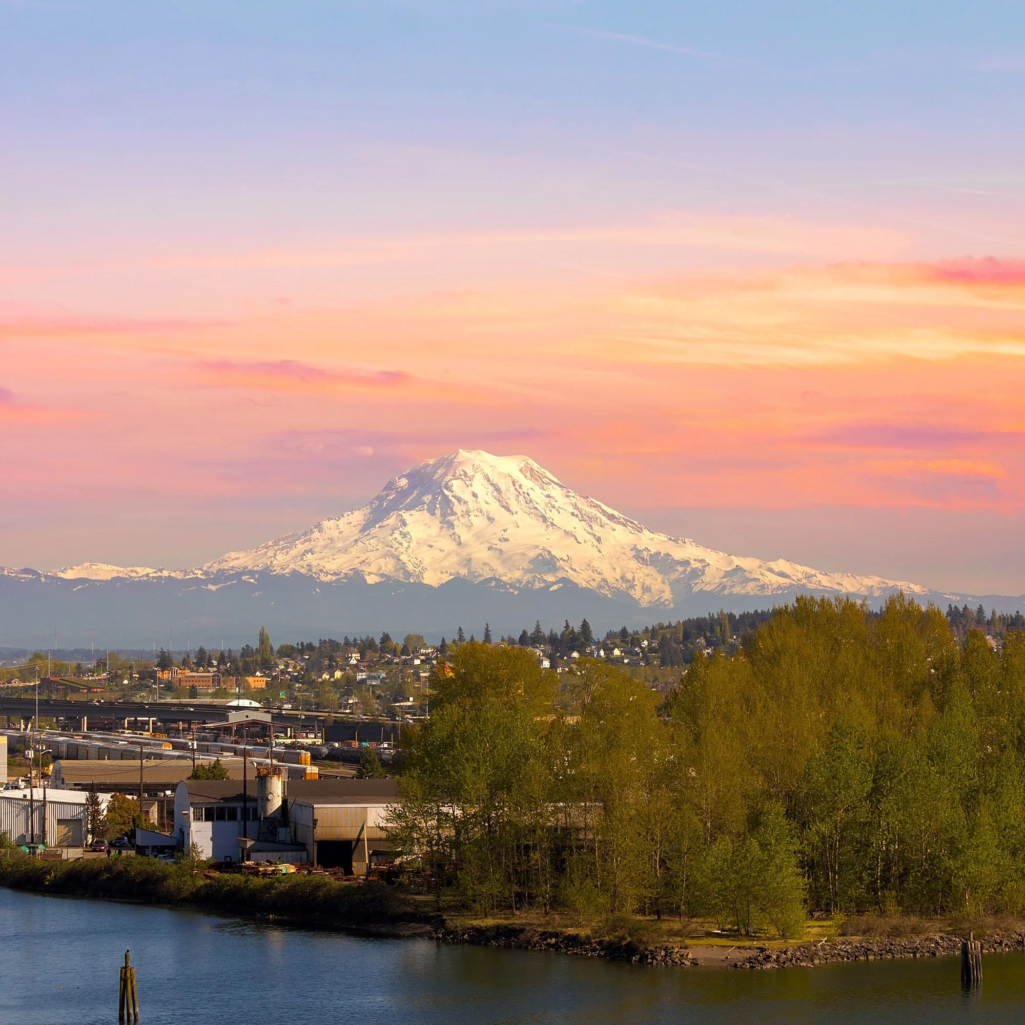 A snow-capped mountain at sunset above the Tacoma, Washington, waterfront.