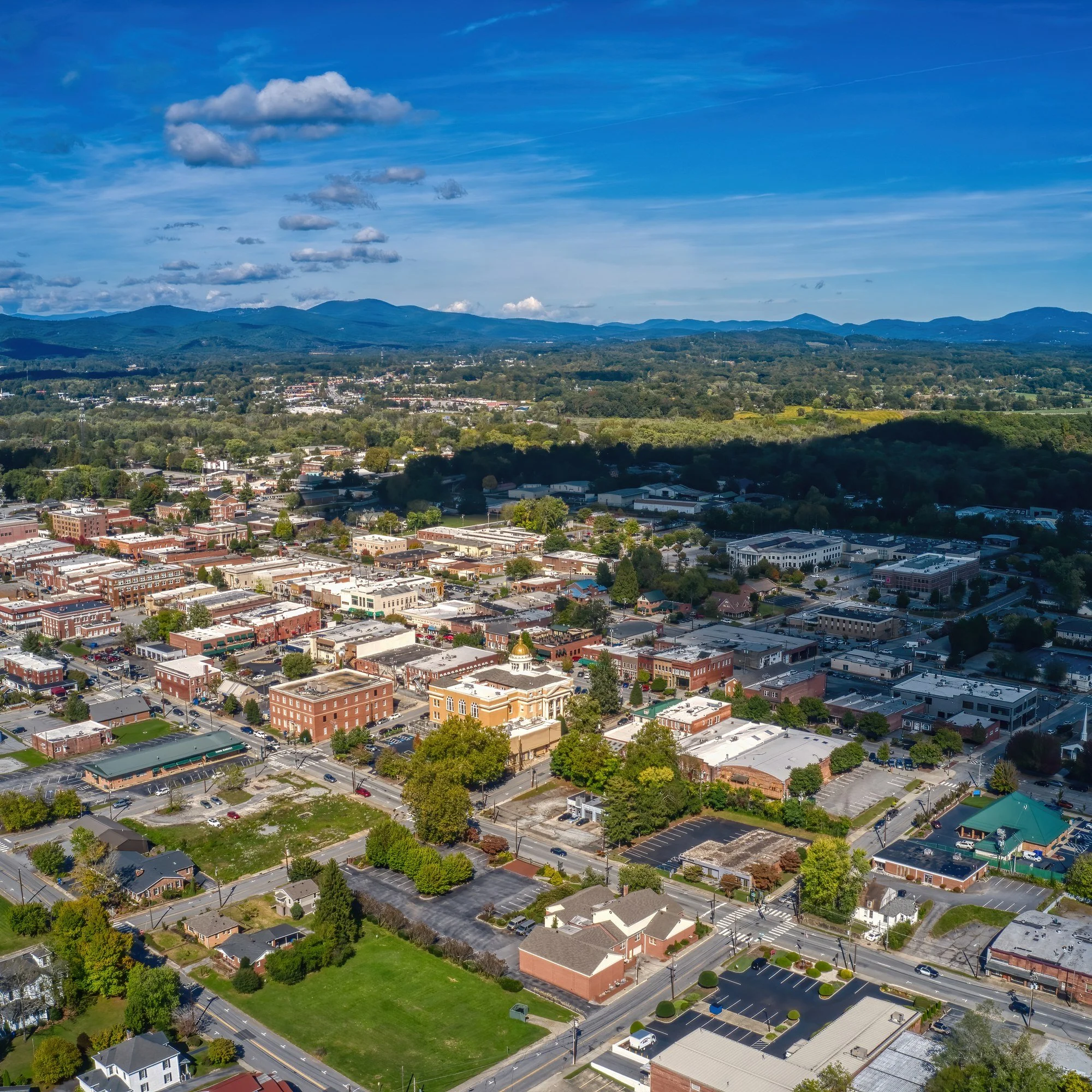 Aerial view of downtown Hendersonville, North Carolina, with the Blue Ridge Mountains on the horizon.