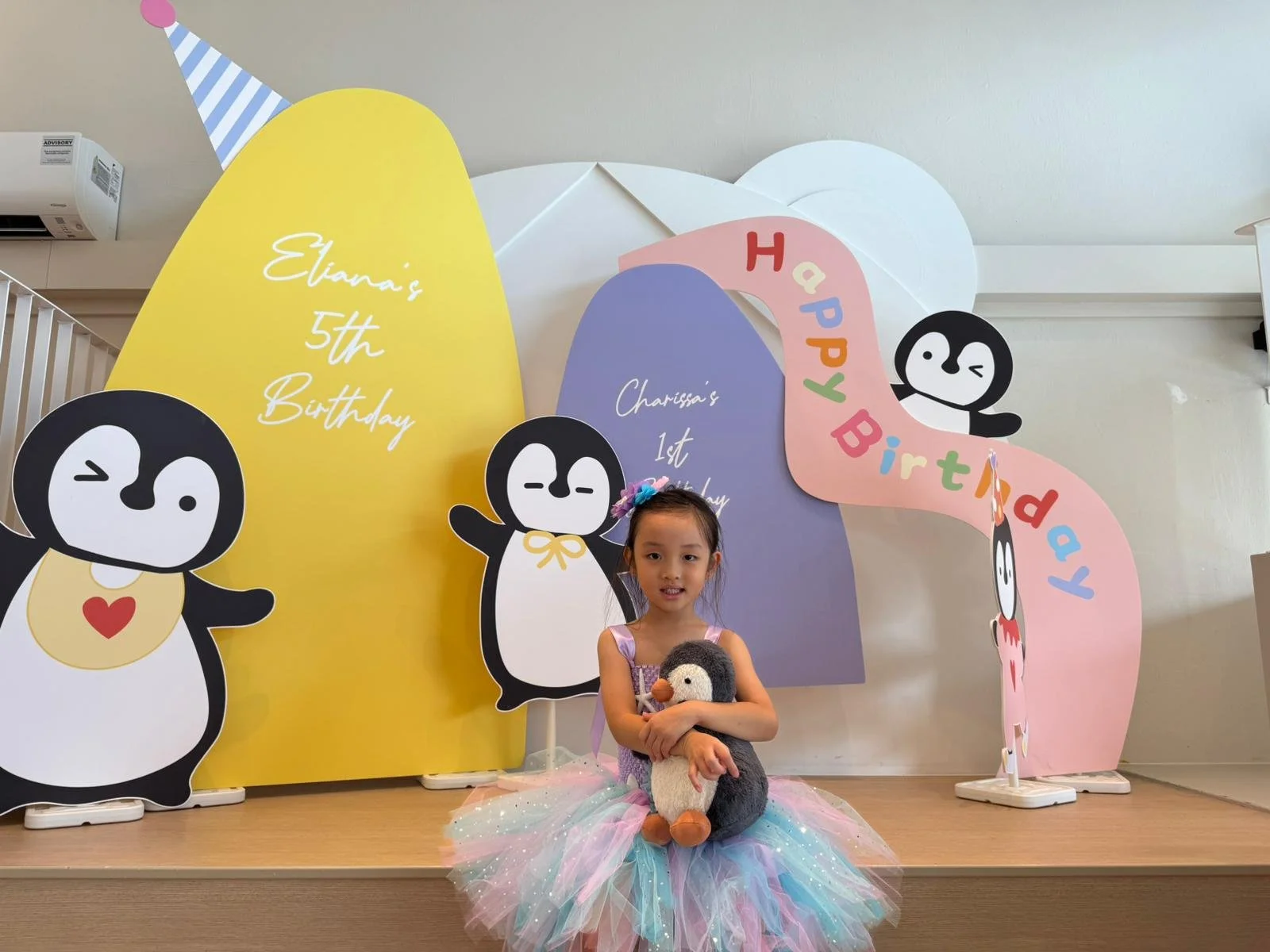 A young child taking photo infront of her 5th birthday party backdrop at Riri’s Children Playloft, a calm indoor kids party venue in Singapore's central catchment area, near Bishan, Toa Payoh, Ang Mo Kio, Lentor, Yio Chu Kang, Bukit Timah, Novena, Ma