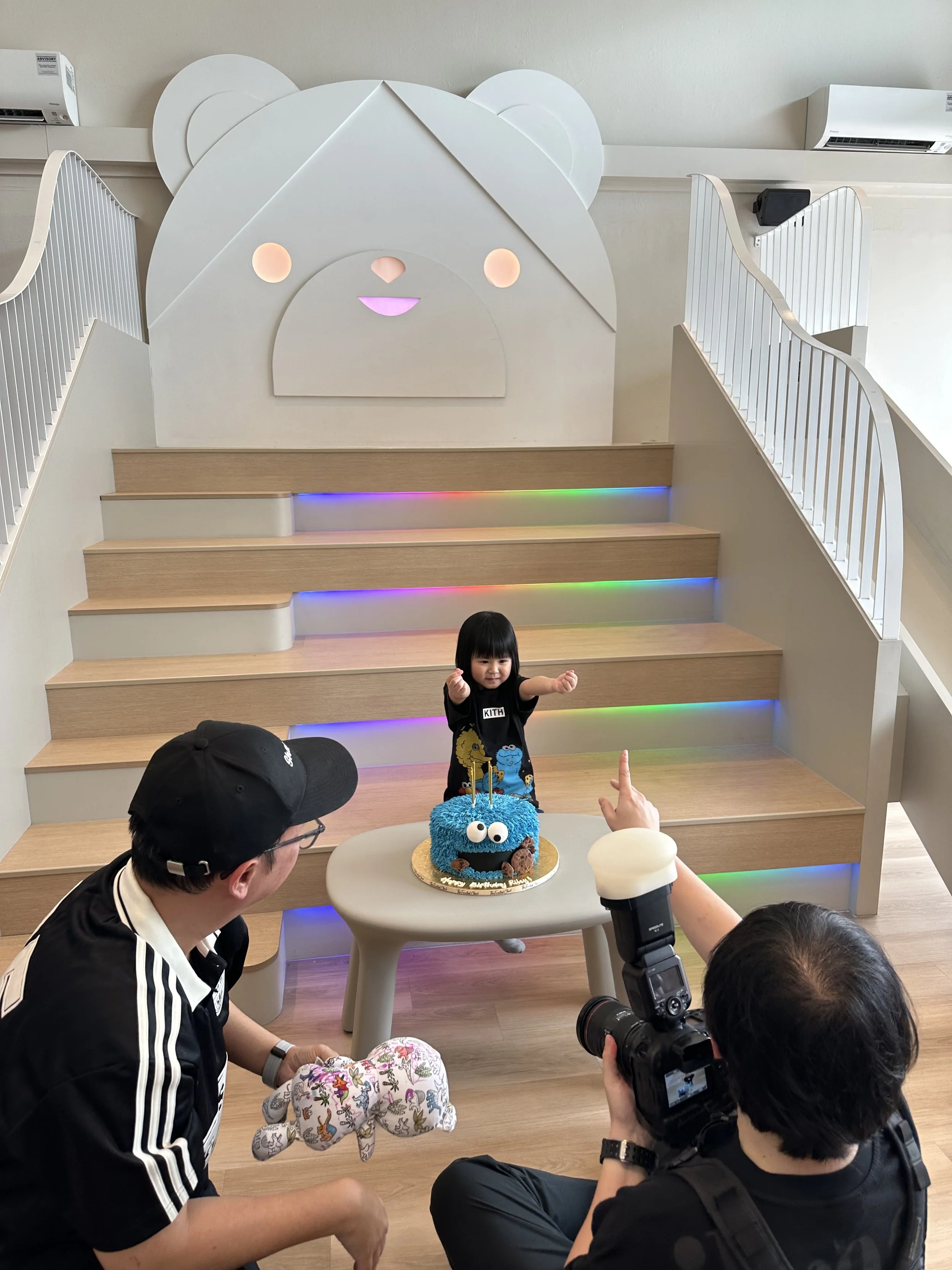 A photographer taking a photo of a 4 year old girl who celebrated her birthday at Riri's Children Playloft, a calm and beautiful toy museum located at Upper Thomson, at the Singapore central catchment area.