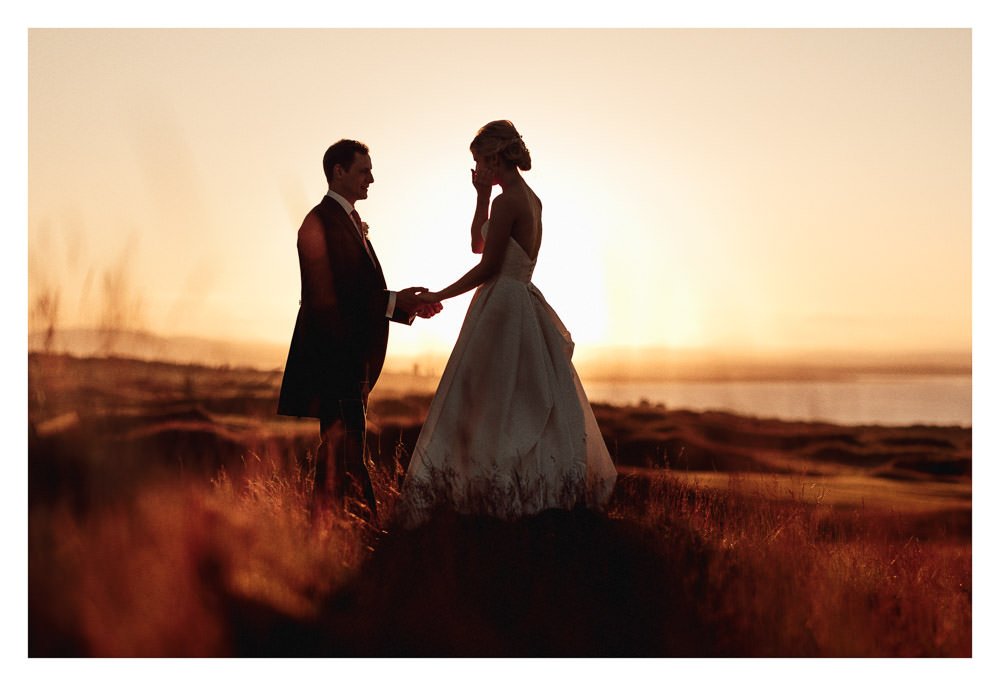 Couple enjoying the sunset at Kinkell Byre, with St Andrews in the distance.
