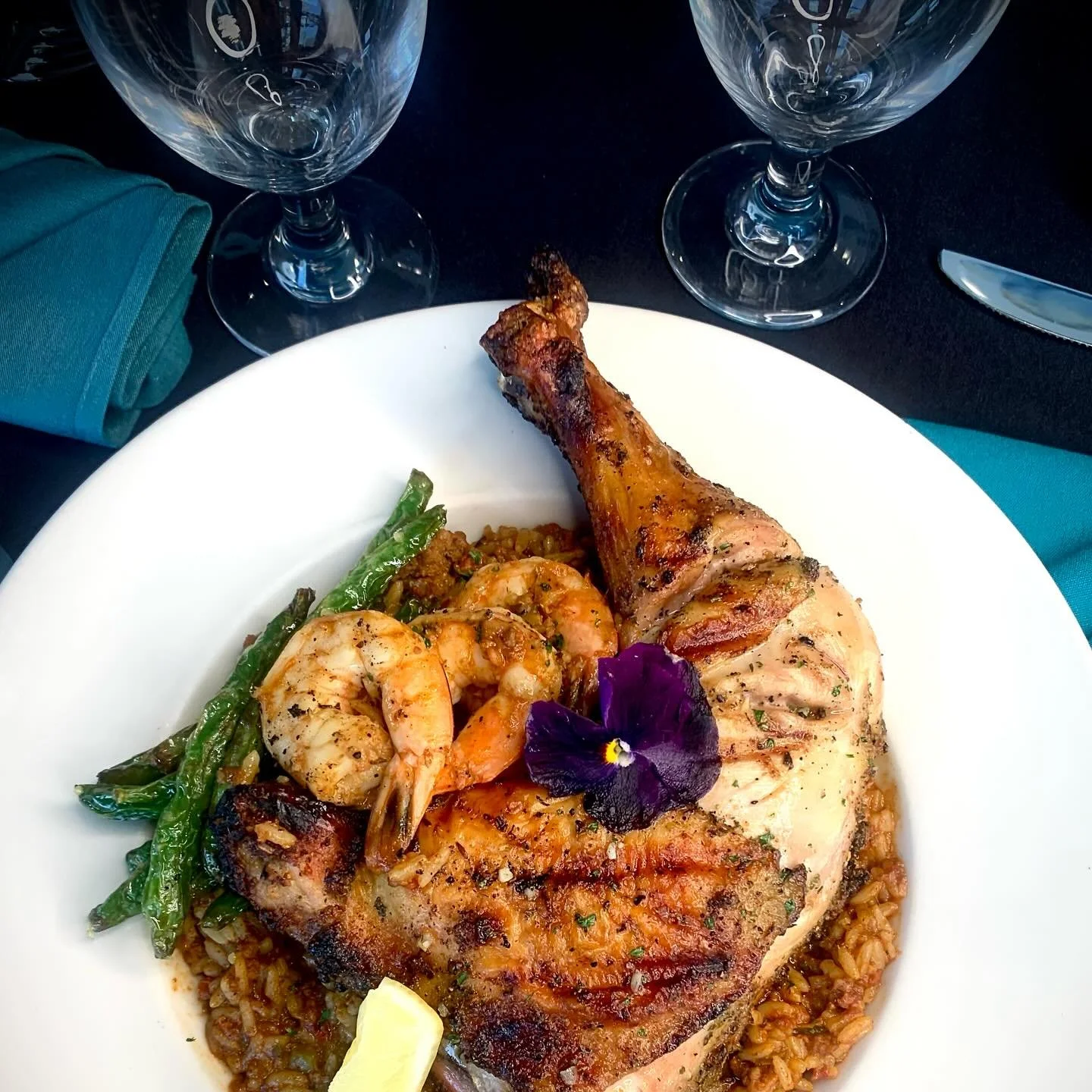 👀Feast your eyes on this beauty &mdash; Chef Matt just dropped a showstopper!

🔥 This flame-grilled, herb-crusted chicken quarter is stacked atop a bed of smoky andouille sausage jambalaya,  crowned with succulent shrimp &amp; served with green bea