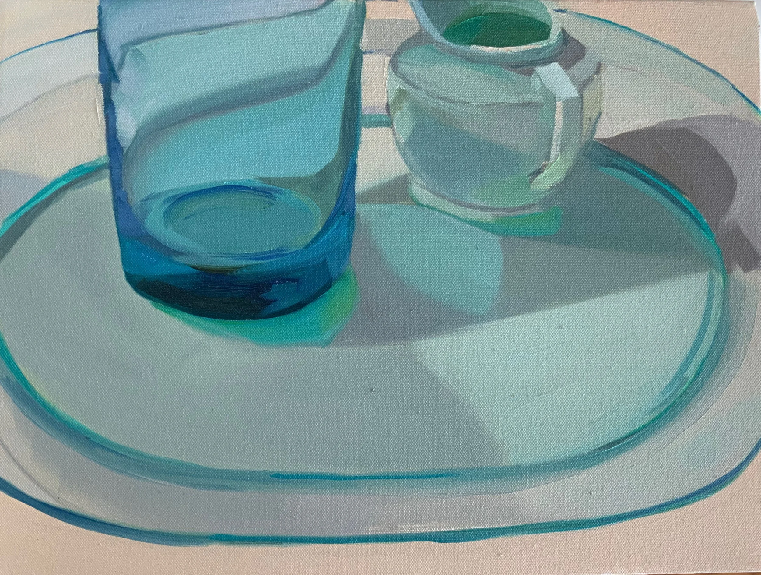 An oil painting of a clear blue glass, a small white pitcher on an oval white tray with a blue rim, casting shadows of different colors on a white surface.
