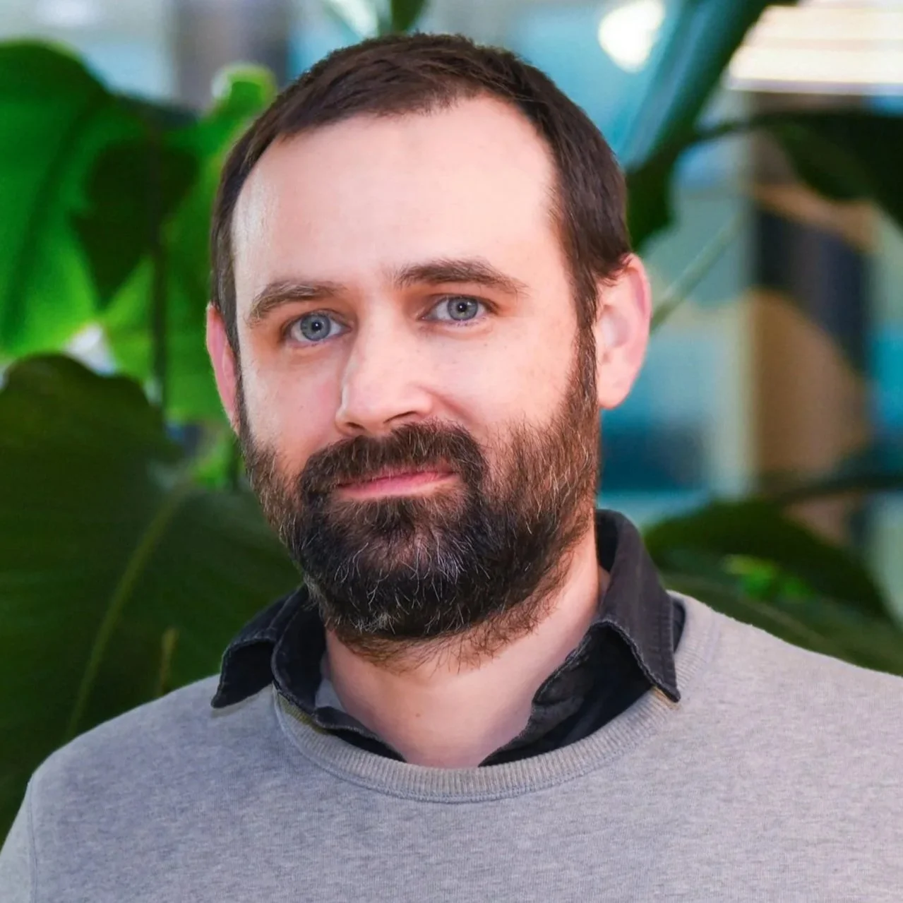 Black and white close-up of a bearded man with short hair, looking slightly to the right.