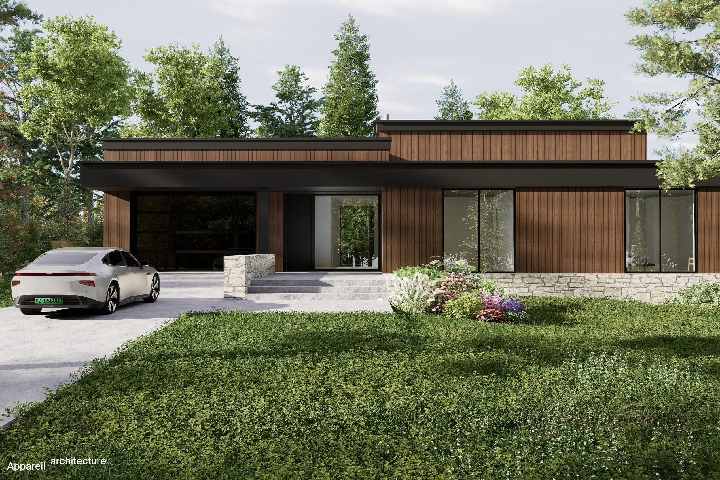 Modern two-story house with brown wood siding, large windows, stone stairs leading to front entrance, and a driveway with a silver car parked. There is a grassy yard with a flower garden and trees in the background.