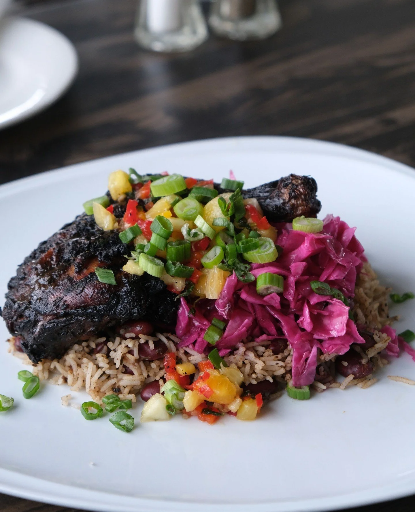 Chef Johnny's Jerk Chicken 🤤 Marinated &amp; grilled jerk chicken thigh⁠
with house pickled red cabbage over rice &amp; peas with pineapple salsa.⁠
⁠
Delicious and nutritious!⁠
⁠
#kaytooatblue