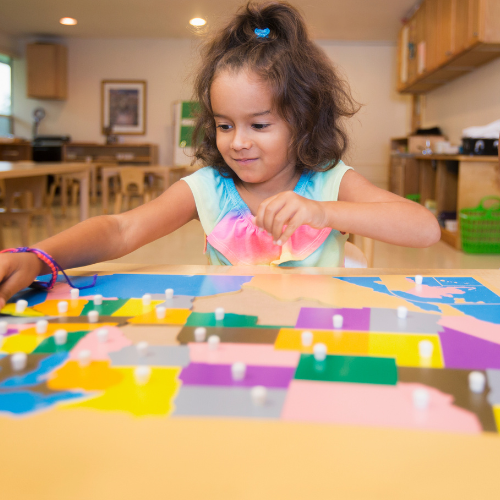 Niña trabajando con mapa de rompecabezas en Ambiente Preparado Montessori