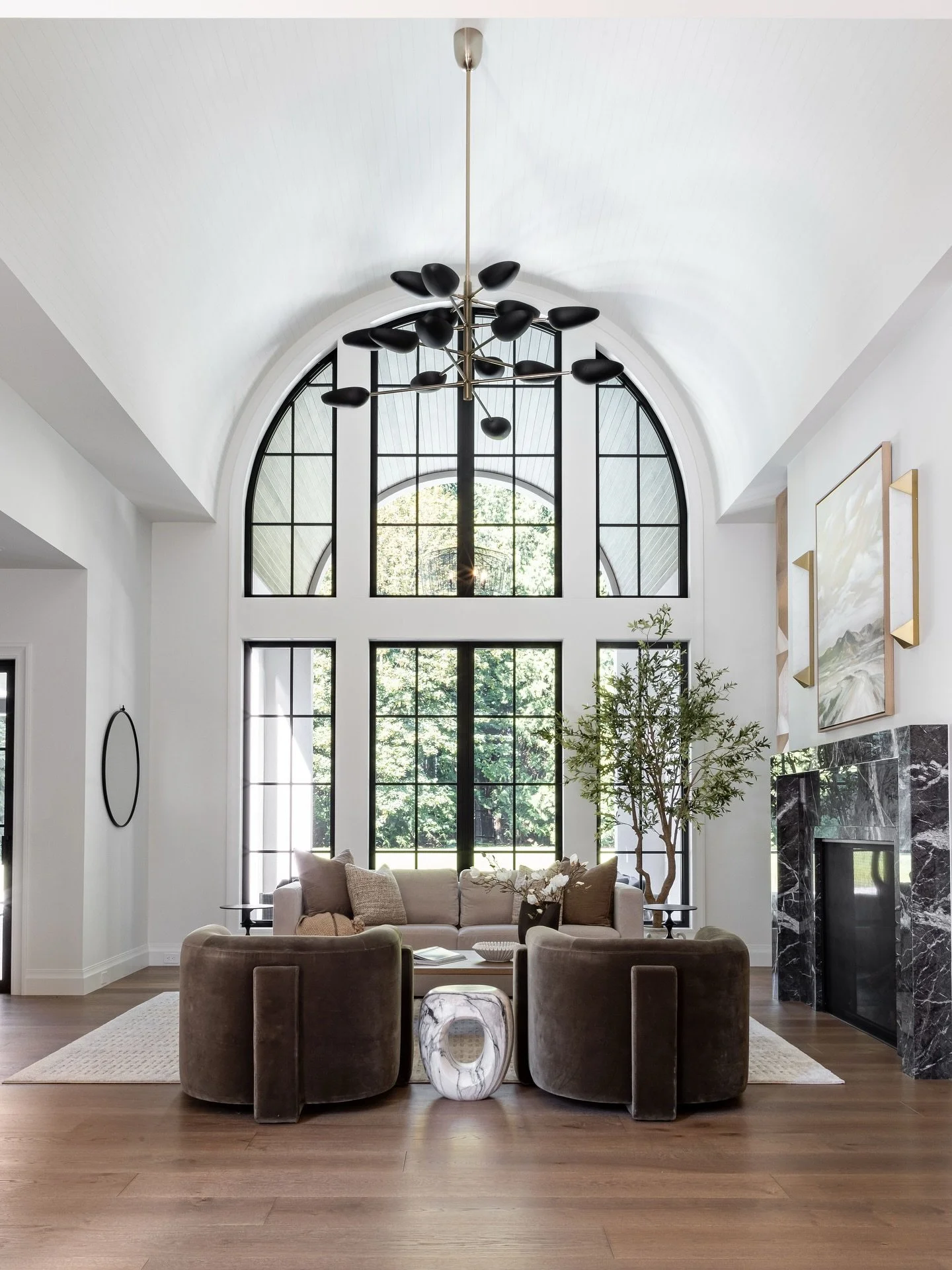All eyes on the sweeping arches and barreled ceiling in this great room! Effortlessly anchored by a bold black marble fireplace surround. 

Interior Designer: @centrestagedesign 
Photographer: @ana__zaha 
Builder: @conversecustomhomes 
Architectural 