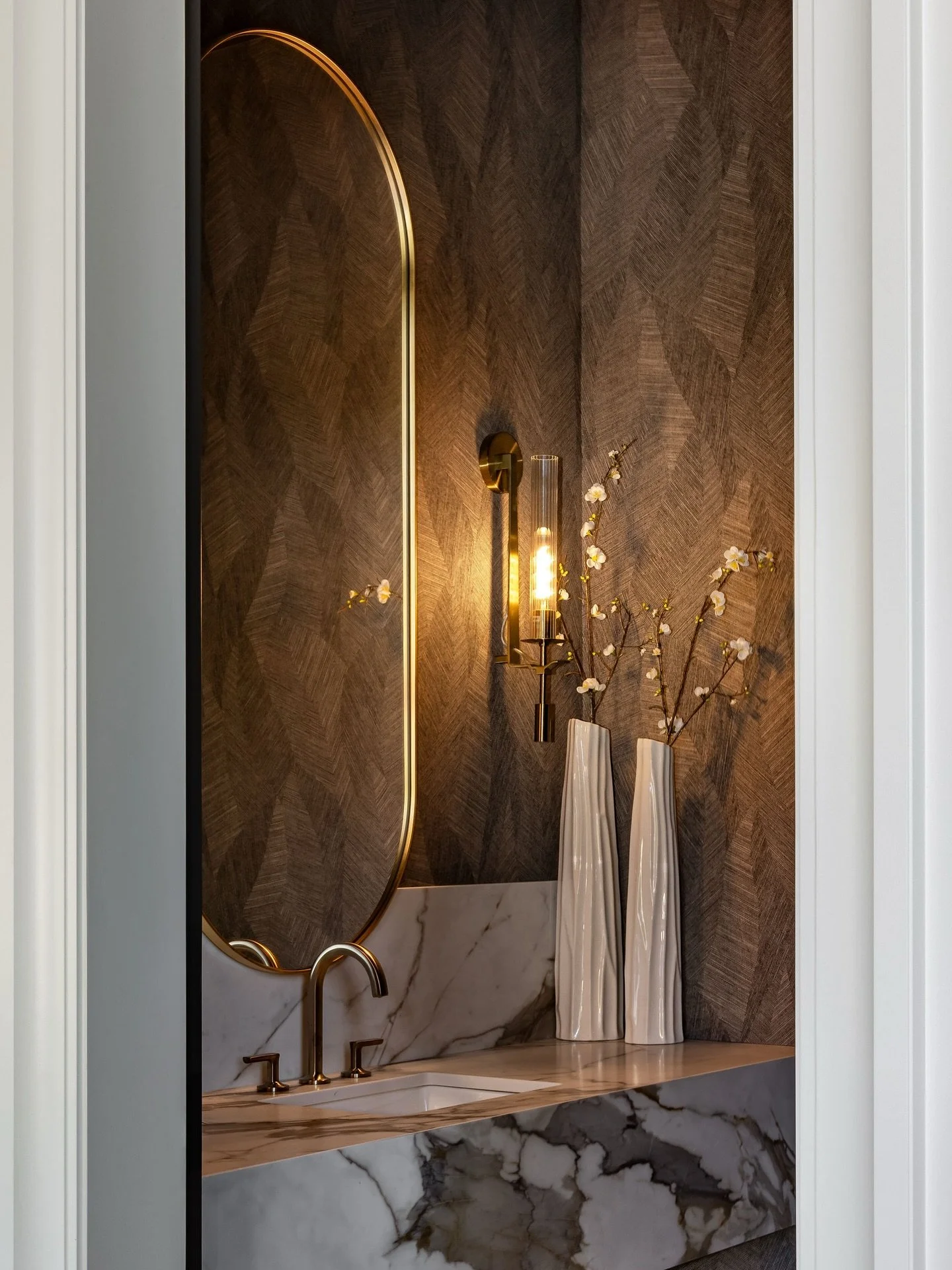This powder room brings a moody yet elegant warmth with luxe textured wallpaper by @artewalls, dramatic stone, and brass finishes, creating a look we simply can&rsquo;t get enough of! 

Interior Designer: @centrestagedesign 
Photographer: @ana__zaha 