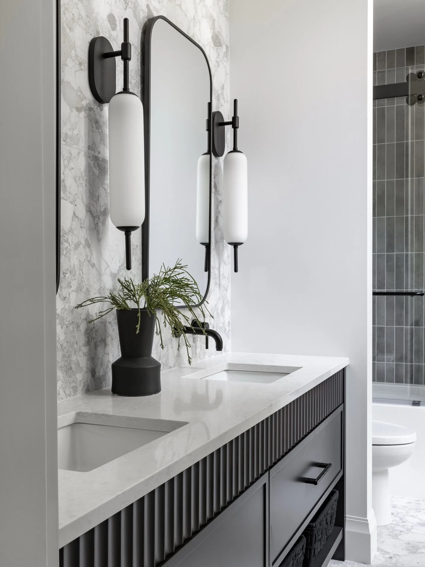 Scroll stopper!

We designed this boys&rsquo; bathroom to feature a replica Ceppo di Gr&eacute; stone, wrapped throughout the space to maximize impact while still feeling durable and hardworking. The fluted vanity brings in a layer of texture and ref