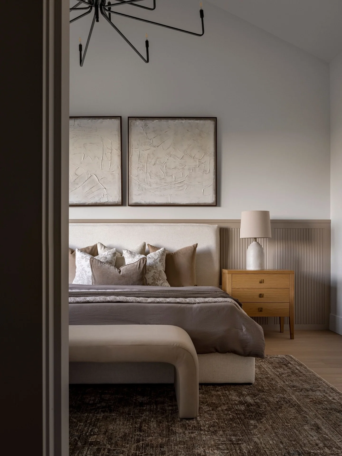 With expansive views all around, the Primary Bedroom in our Vault and View Project embraces its secluded privacy and stunning views. A low-profile feature wall with subtle convex panels introduces texture and visual interest behind the bed without di