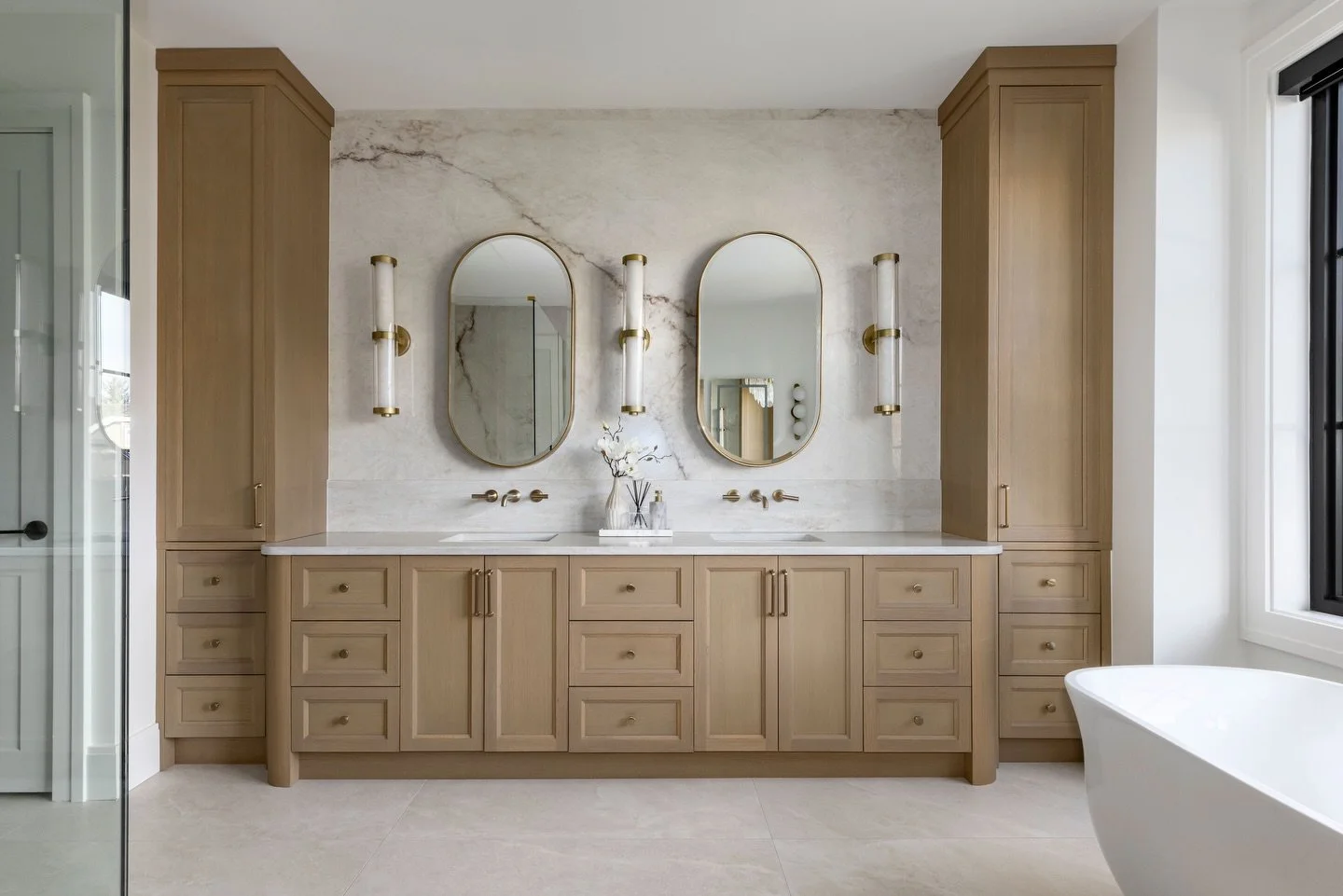 Notice anything interesting? It&rsquo;s all in the curves.

From the mirrors to the millwork, the tub, and even the chandelier, round was the theme throughout this space. The soft, rounded edges create a calm, cohesive design that instantly gives off