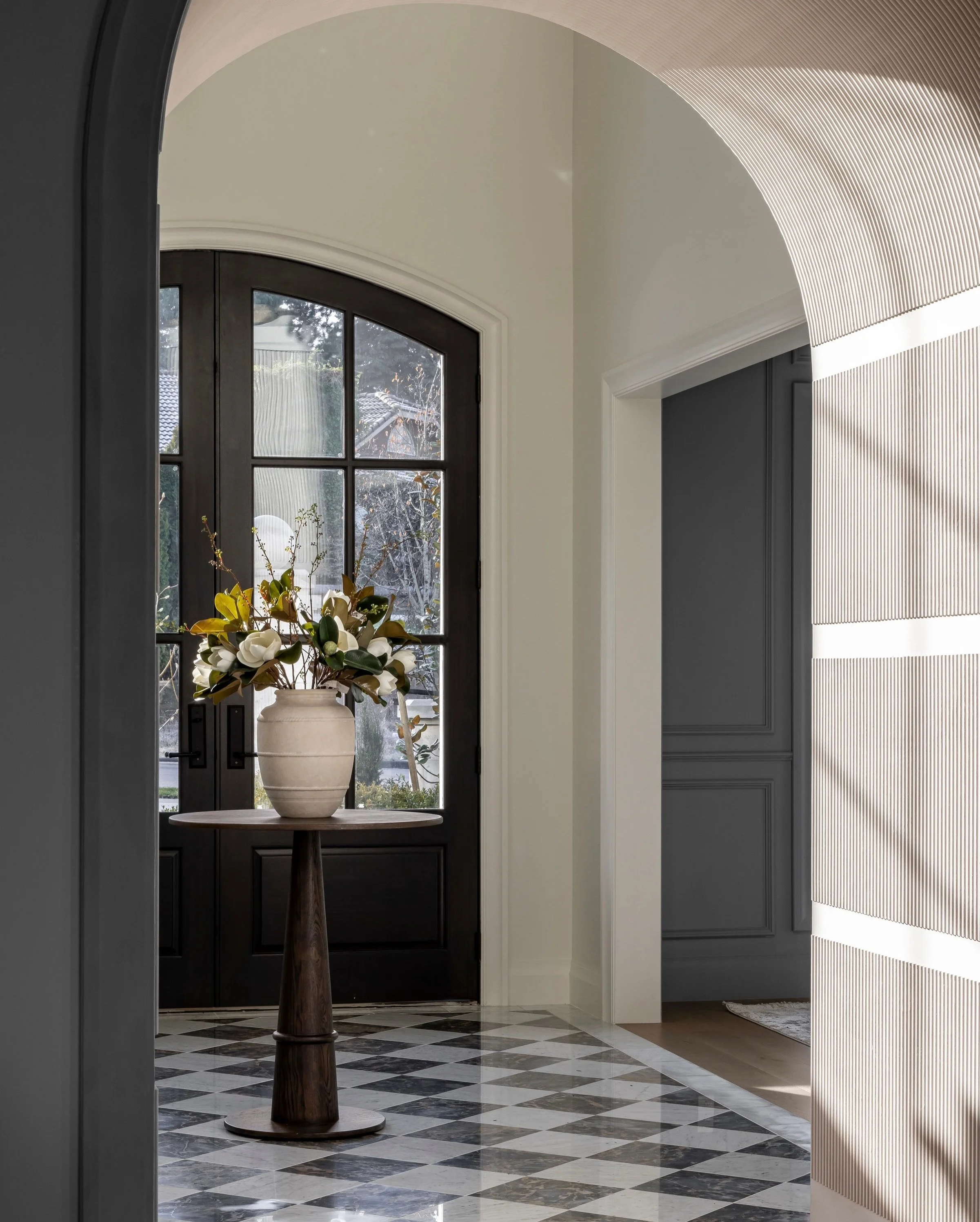Pick your jaw up off the floor!

This space has far too much goodness not to share. Between the foyer and the great room, a barreled hallway creates a true architectural moment. We transformed the passage into a fluted tunnel layered with applied pla