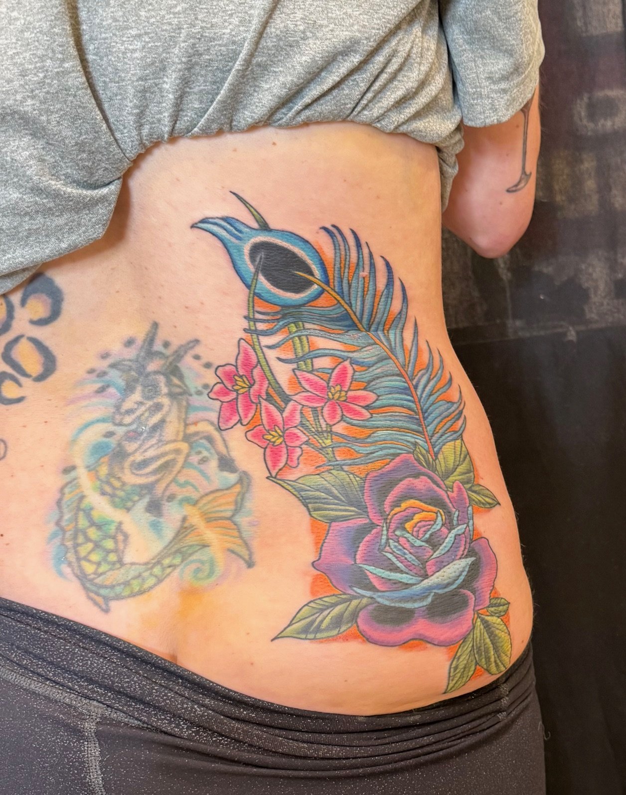 Peacock Feather with flowers covering up old tattoos.