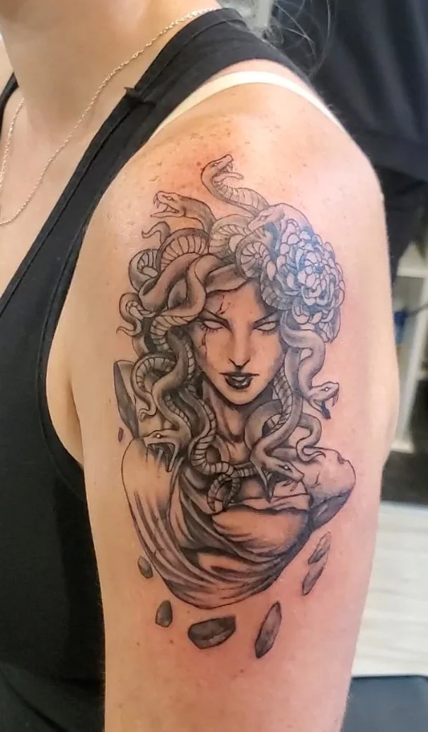 A tattoo depicting an original take on Medusa rendered in Black and Gray by Pete Tapang.  This illustration was made as a custom design for the client.