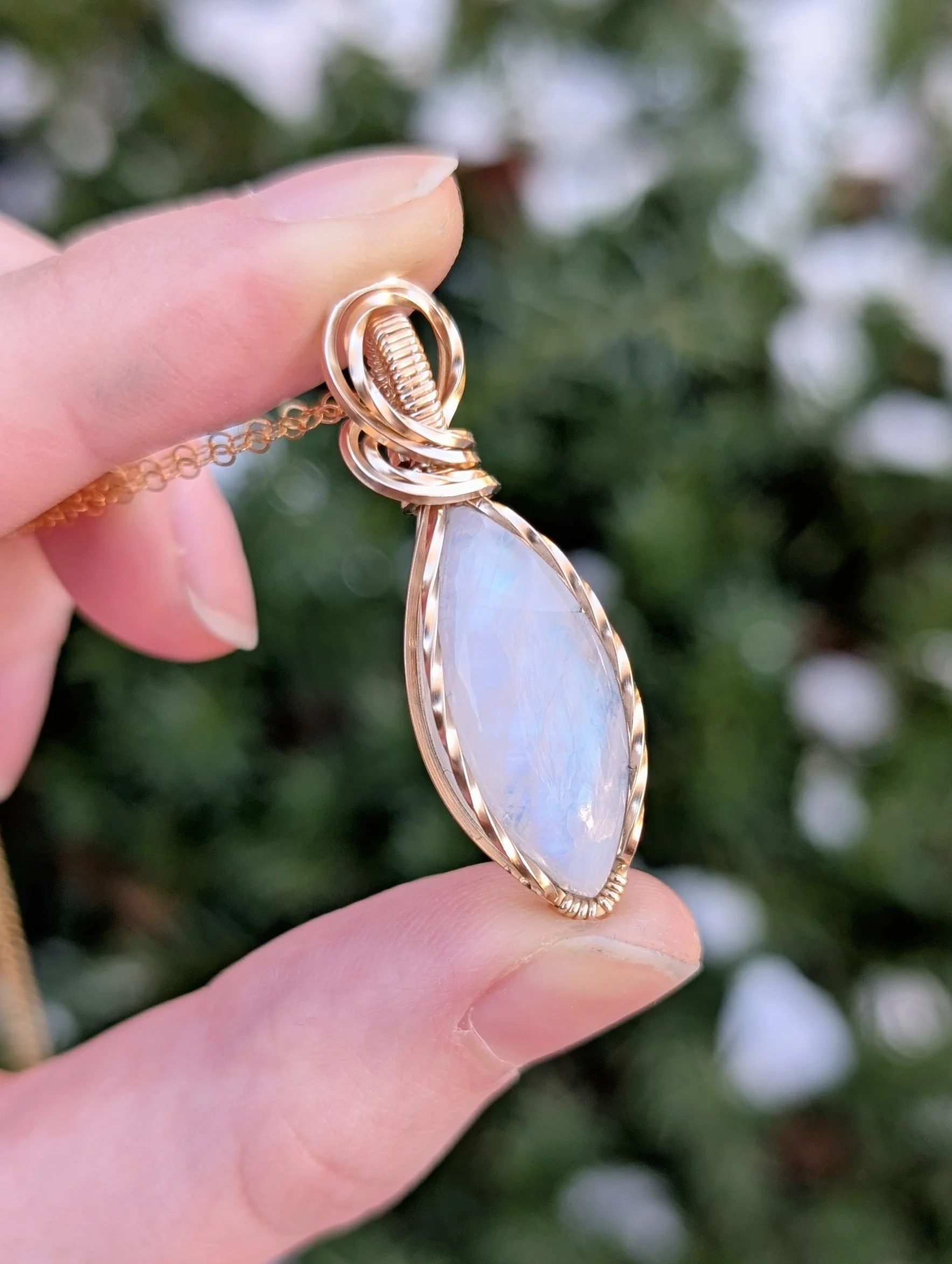 Closeup of a pendant made with a marqui-shaped moonstone and 14k gold filled wire.
