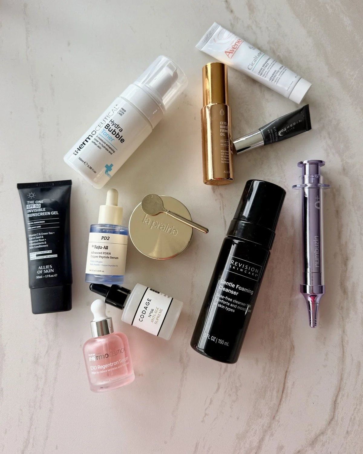 Sydney Sajadi's current skincare products laid out on a marble counter, including La Prairie, Revision Skincare and Allies of Skin