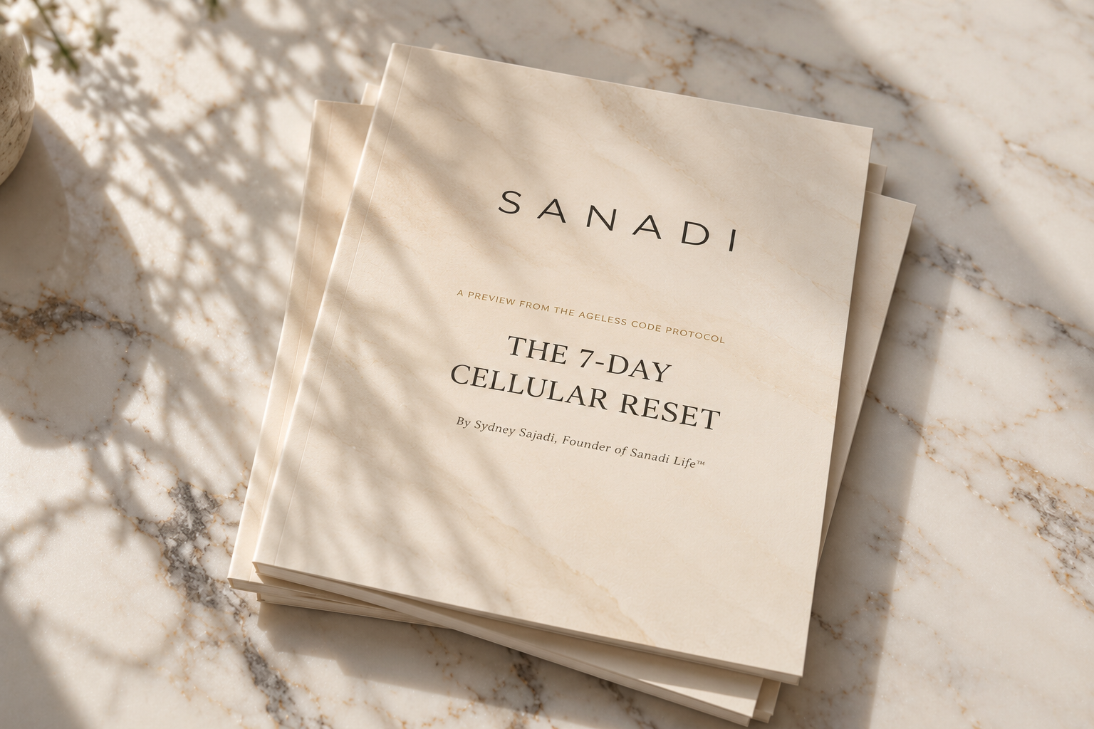 The 7-Day Cellular Reset guide by Sydney Sajadi on a marble surface in soft natural light