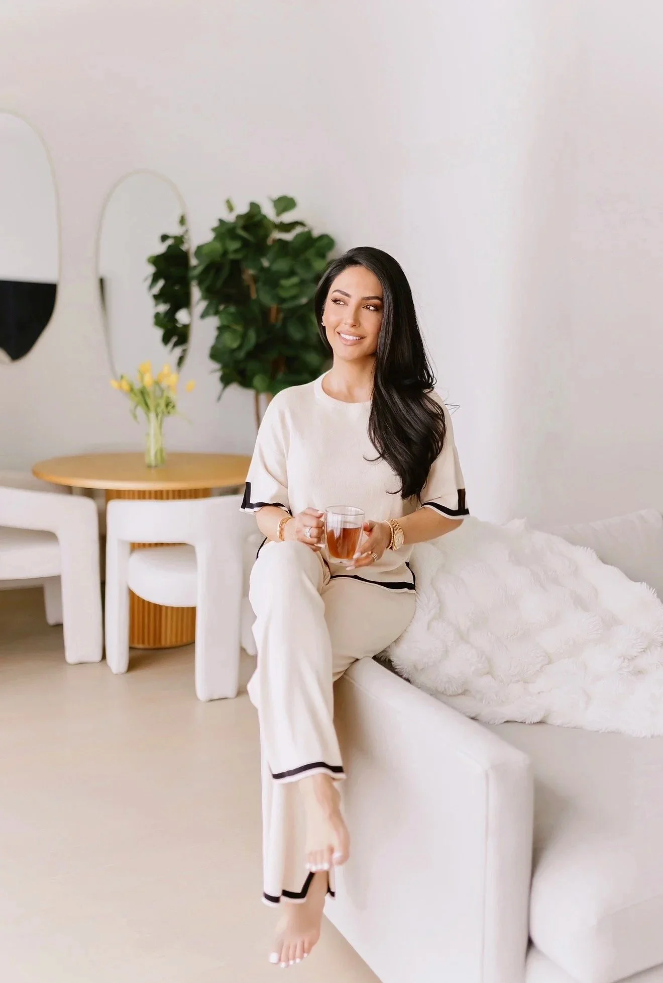Sydney Sajadi, founder of Sanadi Life, sitting in a relaxed setting while enjoying tea, reflecting a personalized and holistic approach to integrative health and wellness.