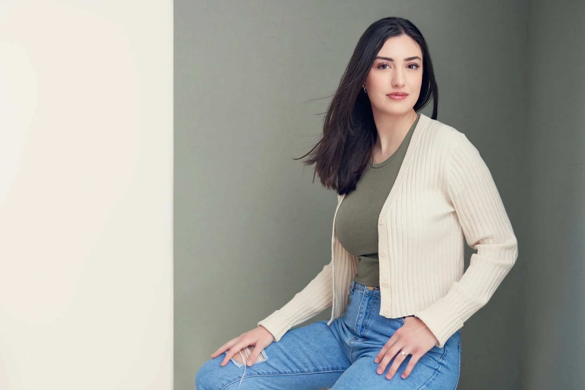 Editorial-style personal branding portrait of a young professional in a contemporary studio setting.