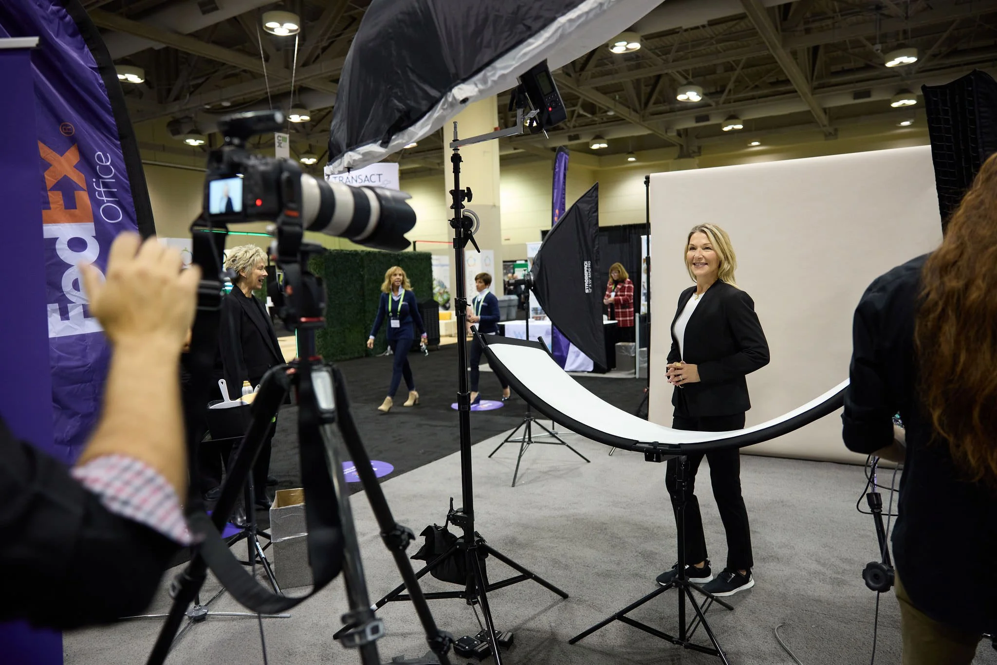 A female conference attending enjoying a headshot station.