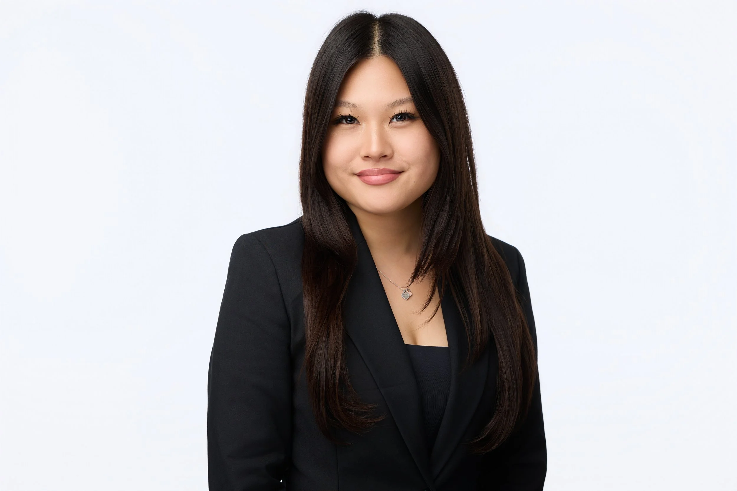 Clean corporate headshot of a confident businesswoman.