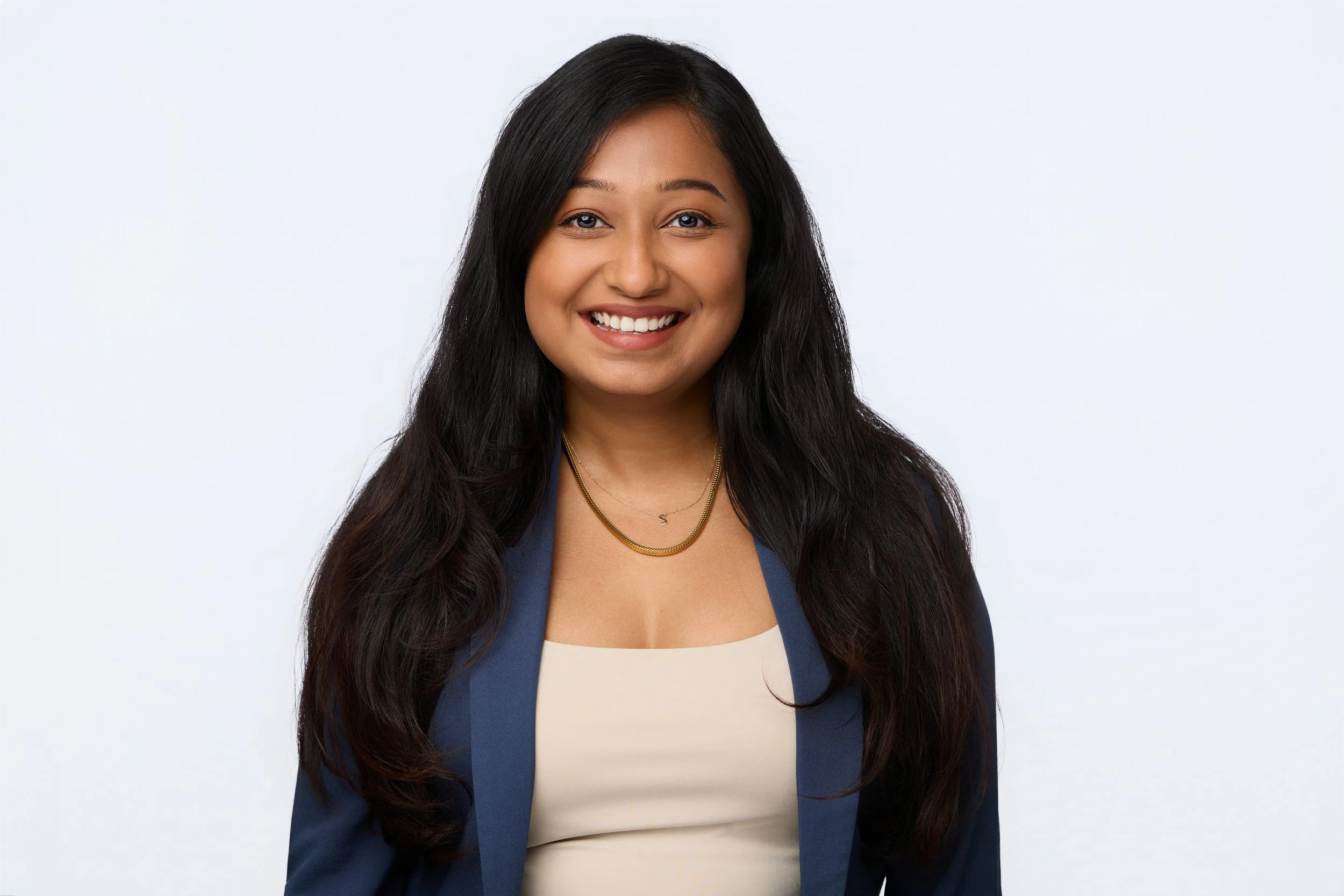 Headshot of a smiling dark-haired businesswoman wearing a navy blazer