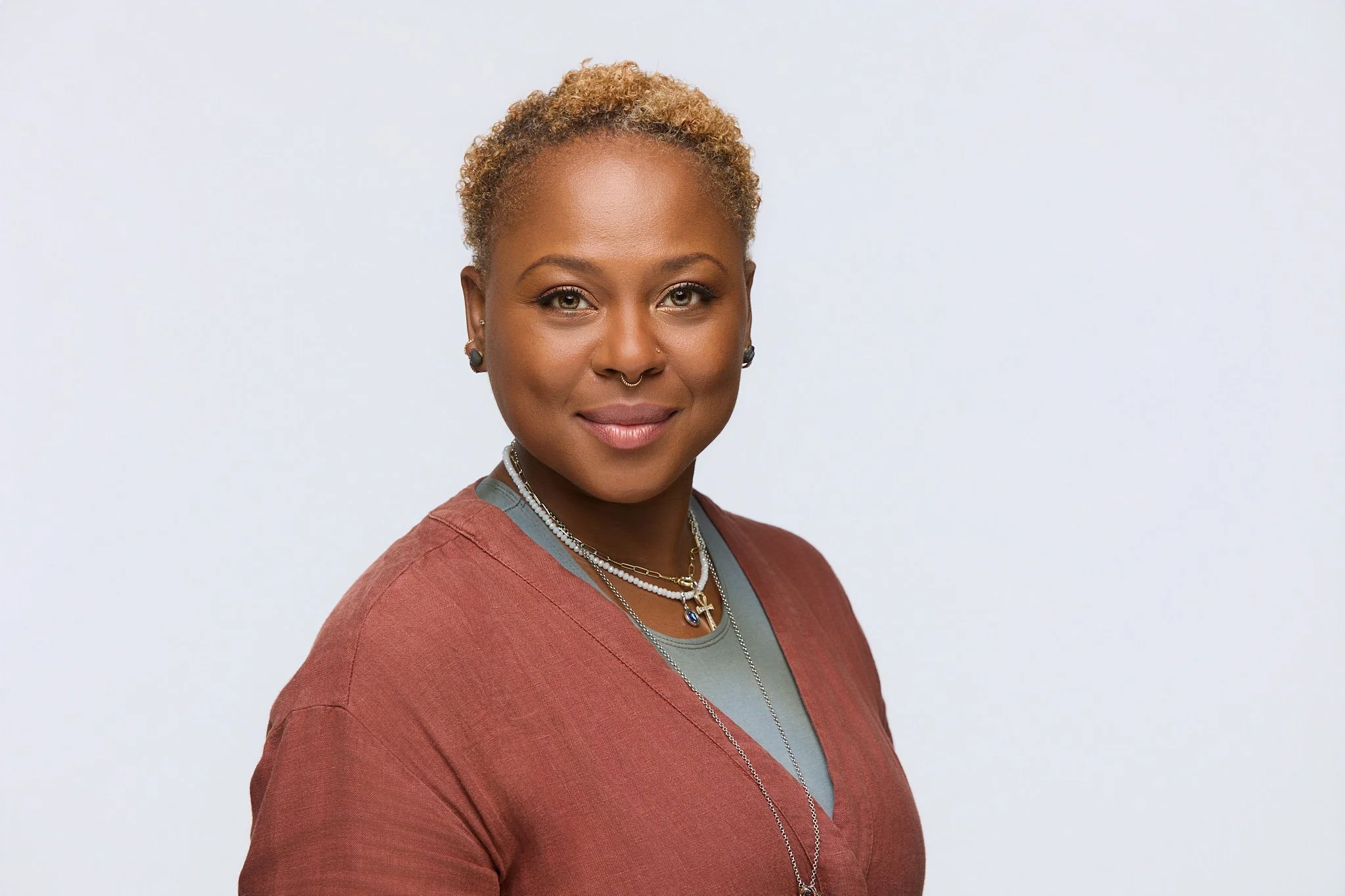 Professional event headshot of Kerry-Ann in a black top against a light neutral background.
