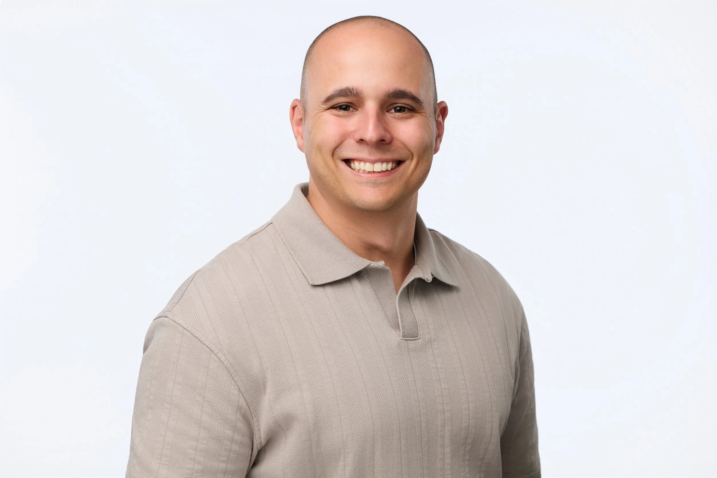 Professional employee headshot of a smiling bald man.