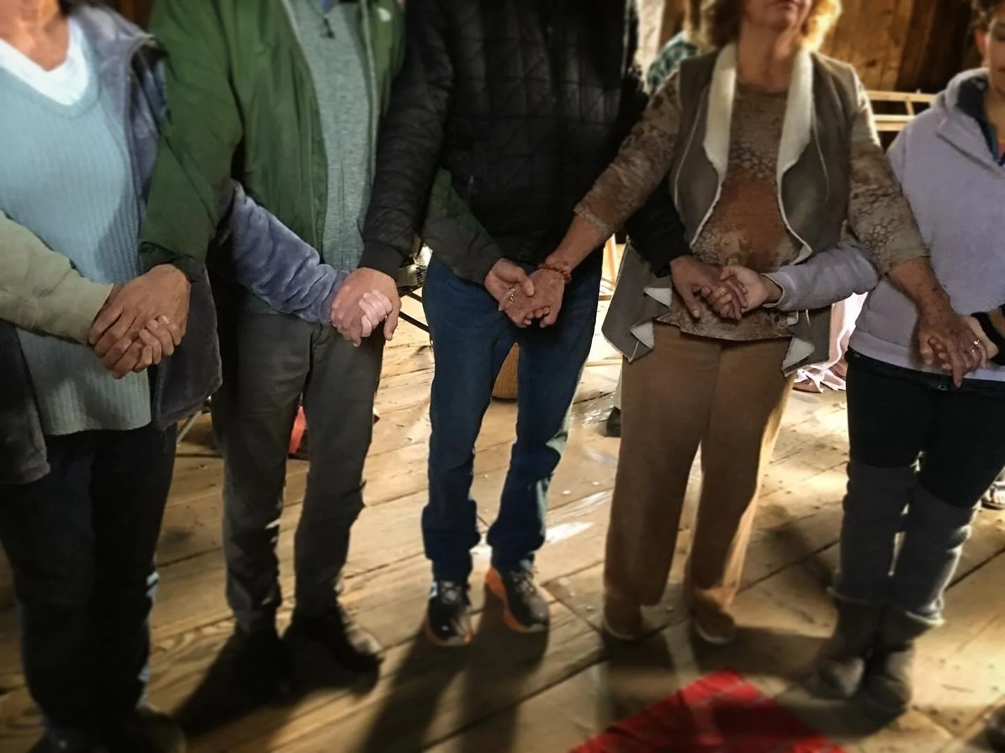 Bridge Songs community choir members holding hands during a gathering.