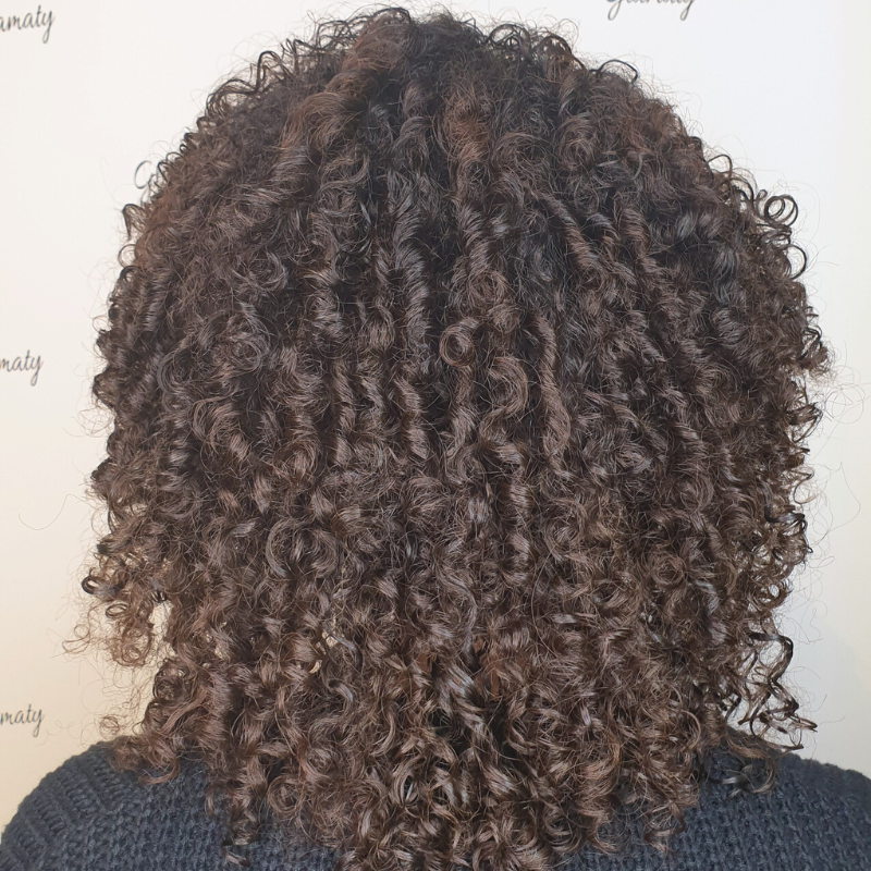 Sint Maarten hair salon dark brown, tightly curled hair.