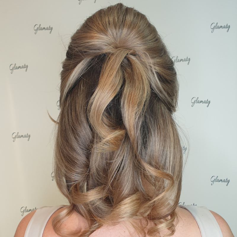 Sint Maarten wedding curled hair in an elegant half-up, half-down hairstyle with soft waves and twisted sections.