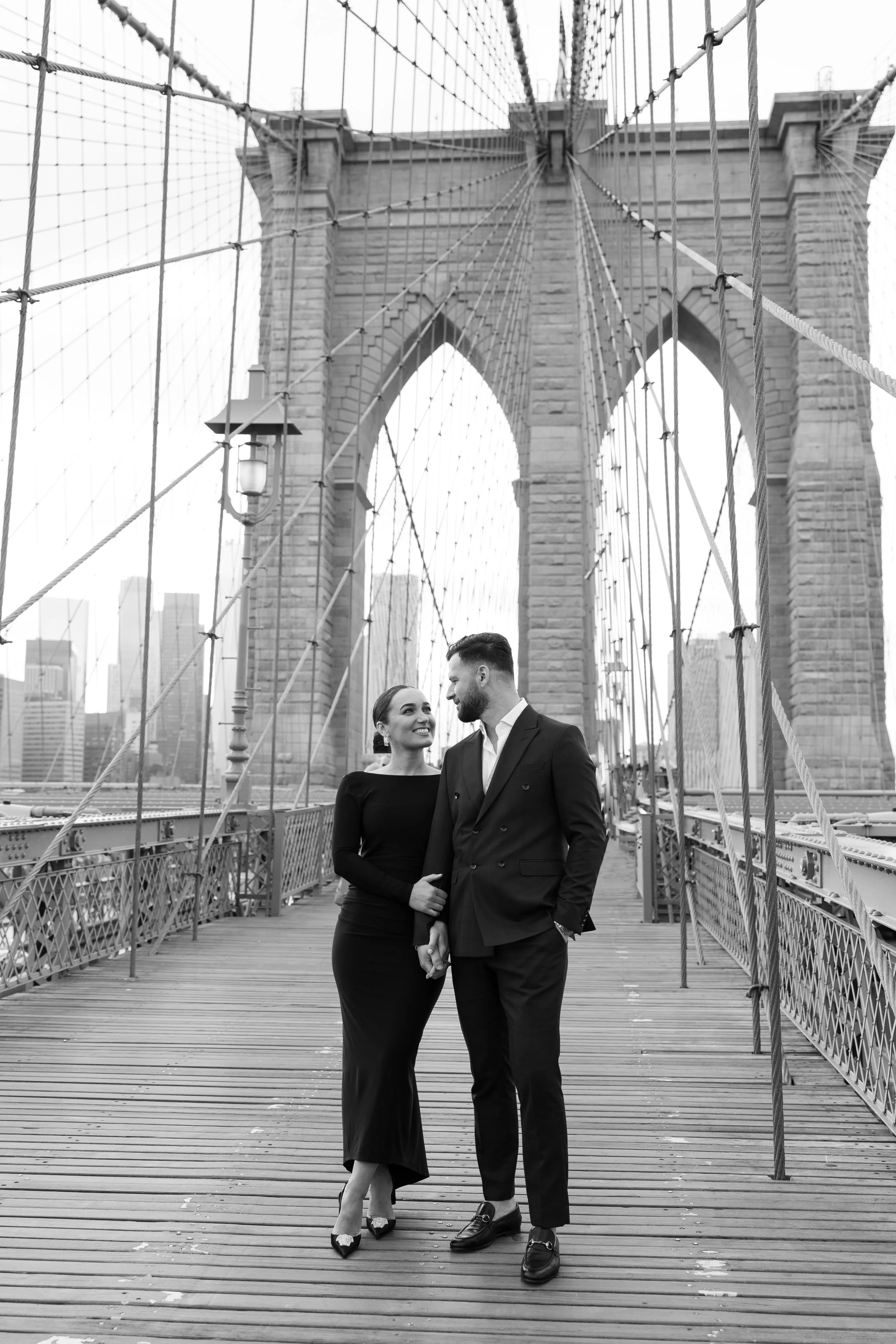 Romantic engagement couple portrait at Brooklyn Bridge in New York City, photographed by Anjeza Dyrmishi Photography.
