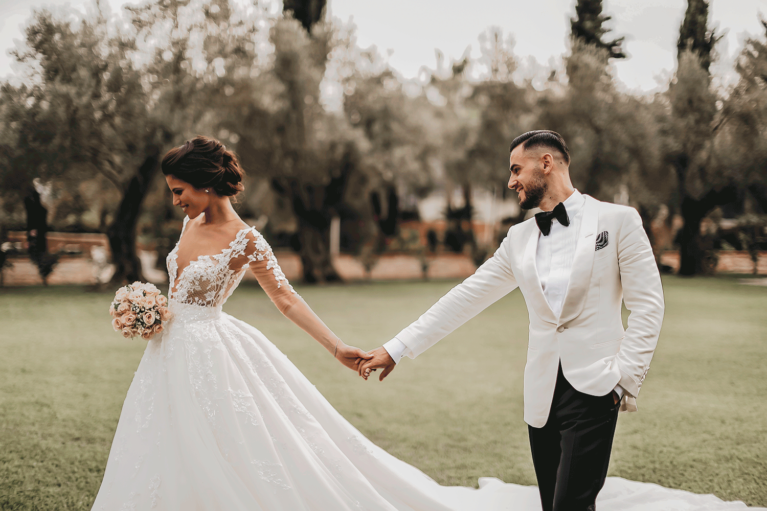 Bride-and-groom-holding-hands-in-the-garden.gif