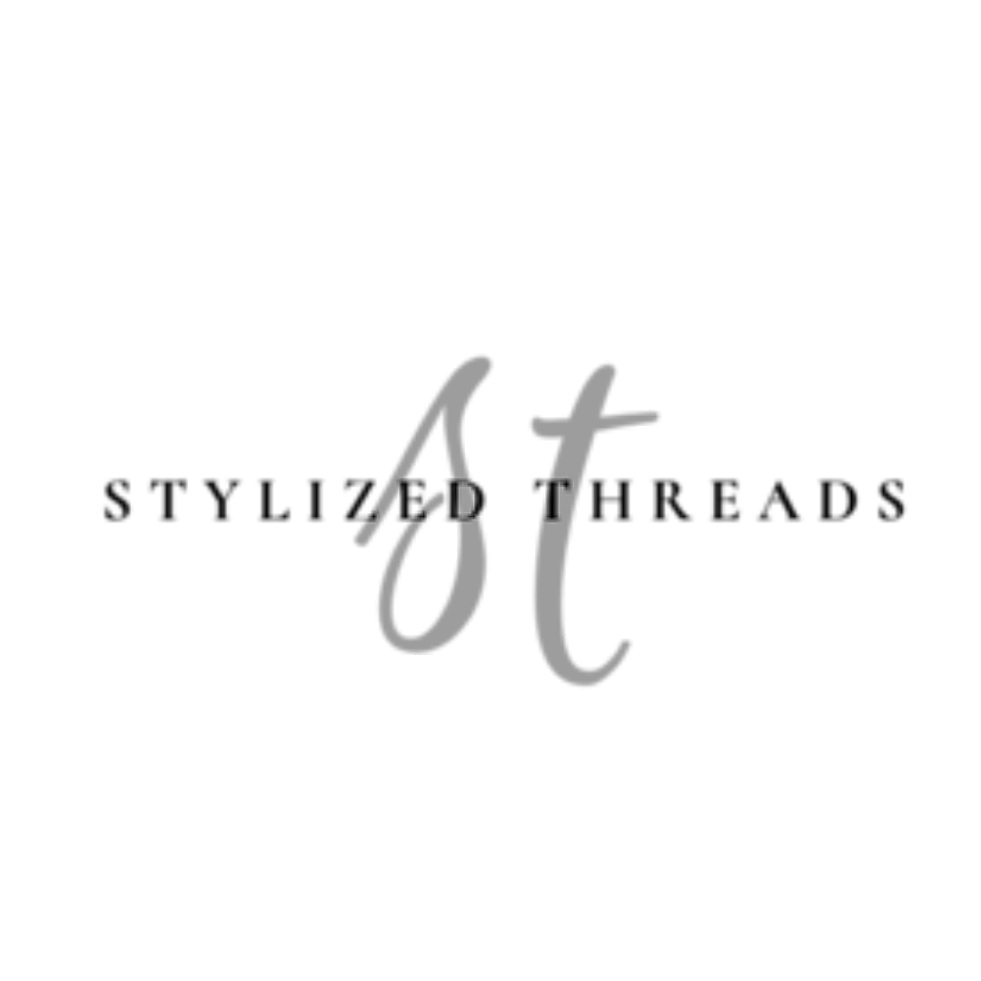 Stylizing Threads Logo: Close-up of black ink calligraphy writing on paper with silver foil accents.
