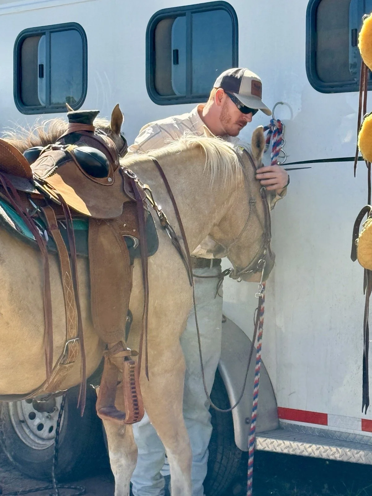 A participant shares a quiet moment with a saddled horse at Golden Forge.