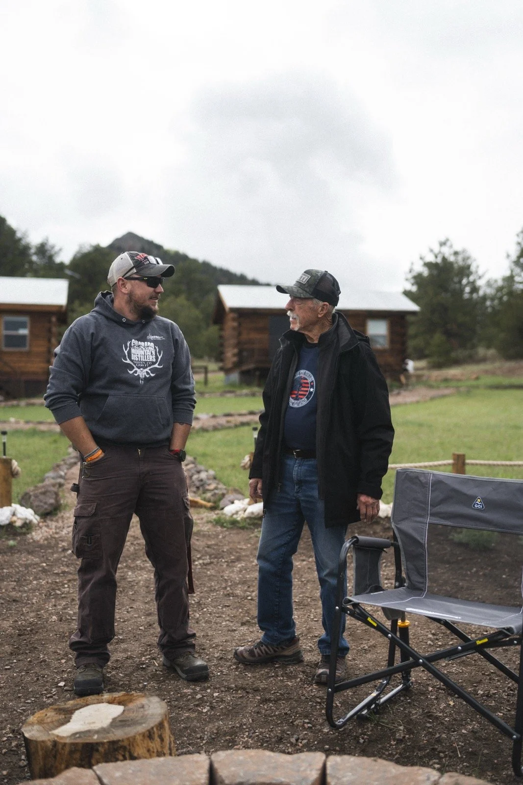 Two people in conversation outside the cabins at Golden Forge.